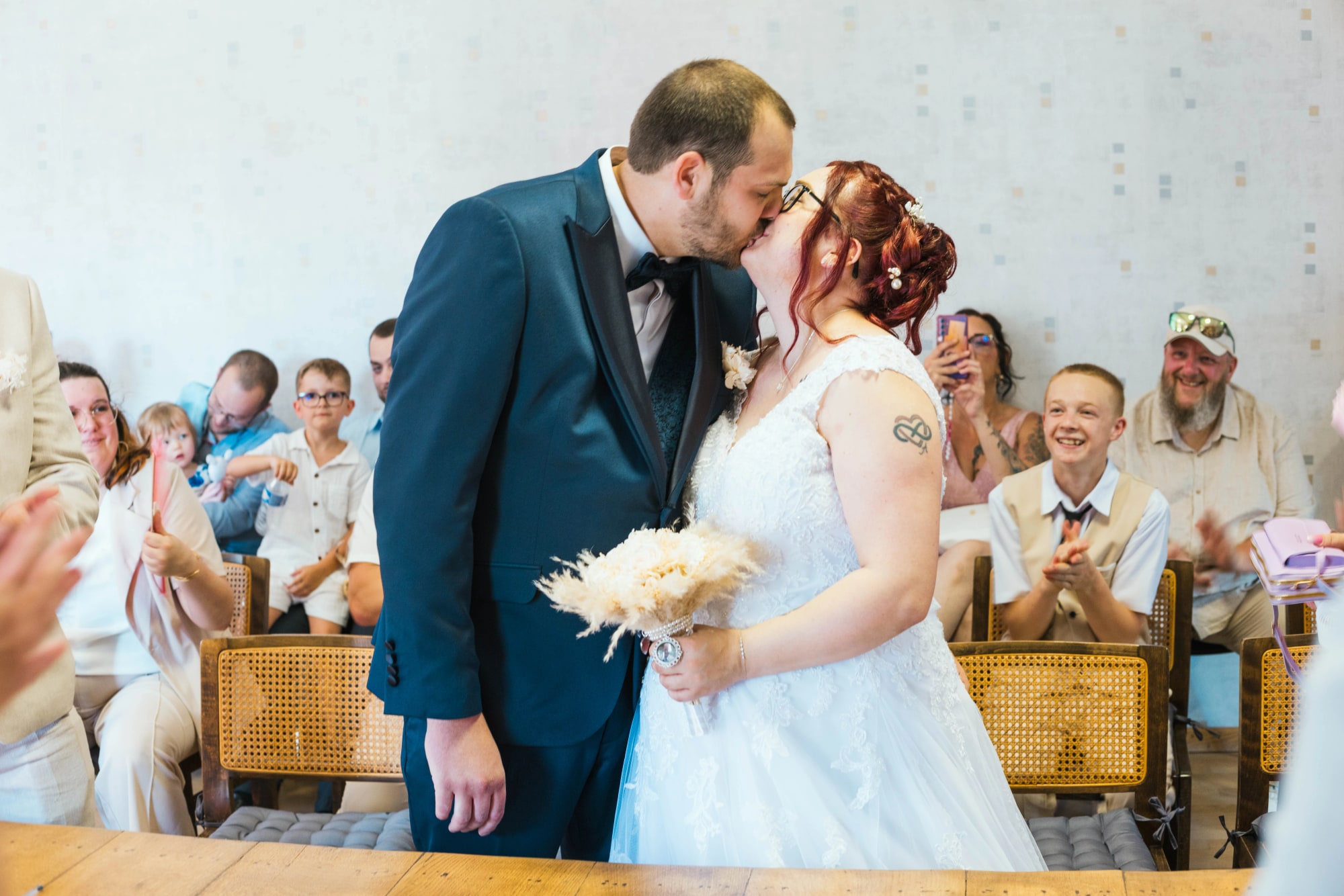 Le baiser d'Angélique et Antoine à la cérémonie civile, sous les applaudissements des invités, mariage au Buironfosse (Aisne), par Jean-Baptiste Argyre (Jaysphotography)