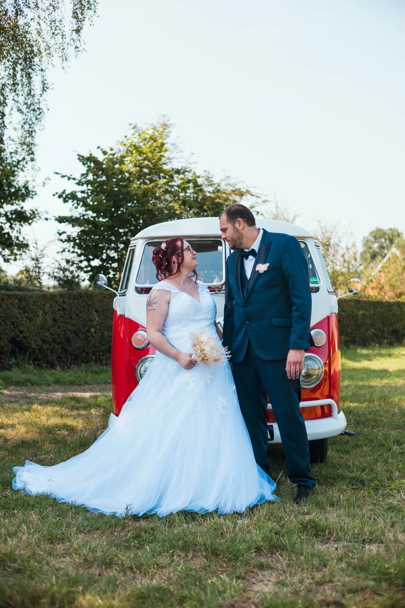 Les mariés face à face devant le combi Volkswagen en lumière dorée de fin d'après-midi, mariage au Buironfosse (Aisne), par Jean-Baptiste Argyre (Jaysphotography)