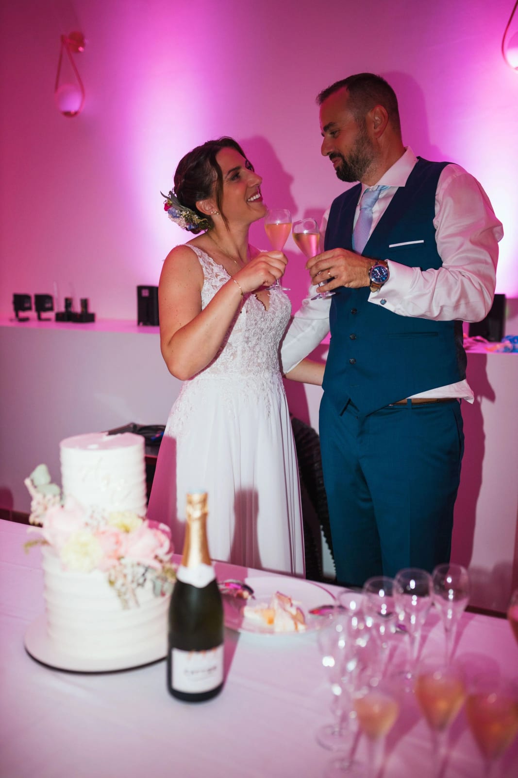 Les mariés une coupe à la main devant leur gâteau de mariage, soirée à La Mézandrée, mariage au La Mézandrée, par Jean-Baptiste Argyre (Jaysphotography)