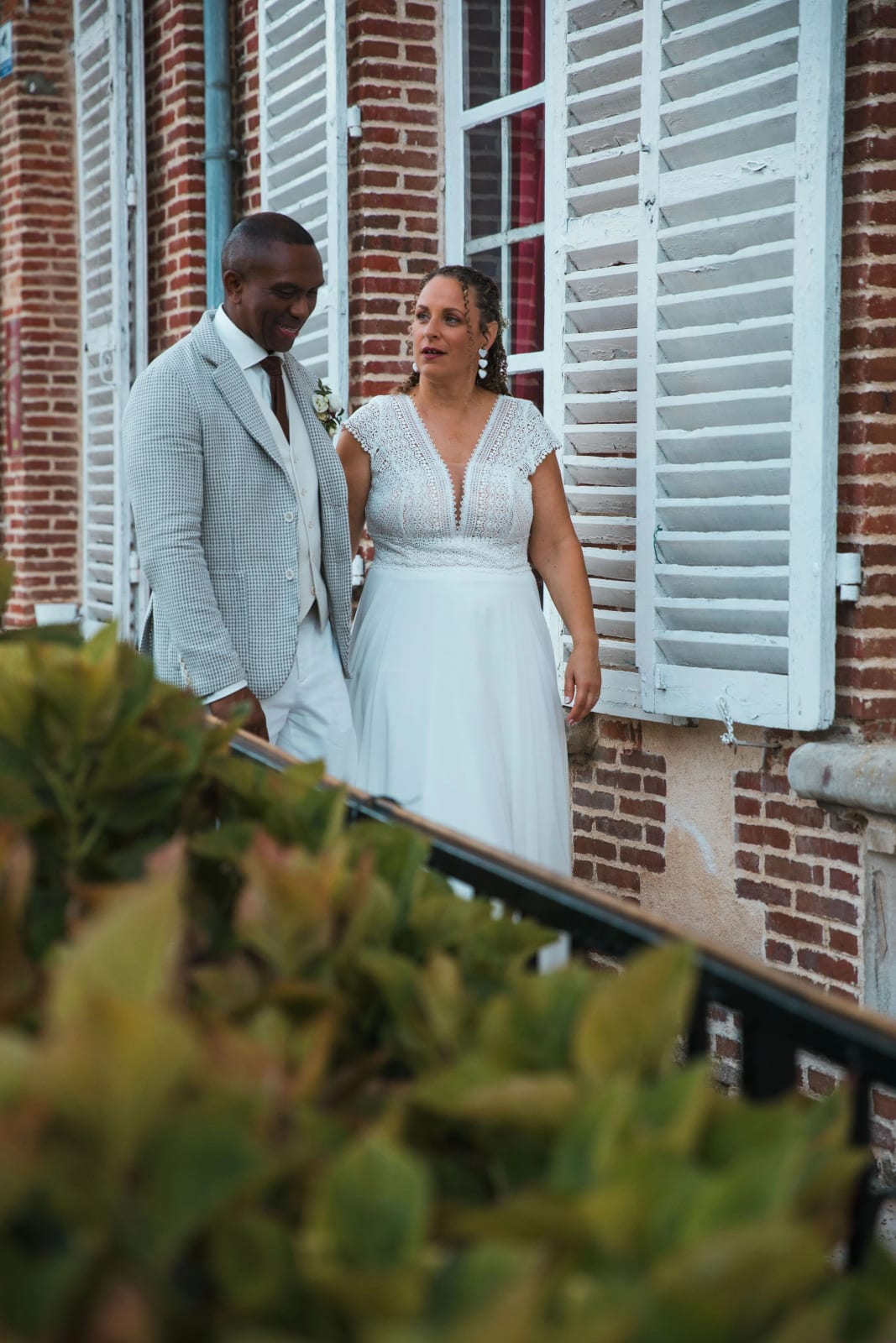 Les mariés sur le perron de brique du Château de la Houssoye, rampe noire et volets blancs, mariage au Château de la Houssoye, par Jean-Baptiste Argyre (Jaysphotography)