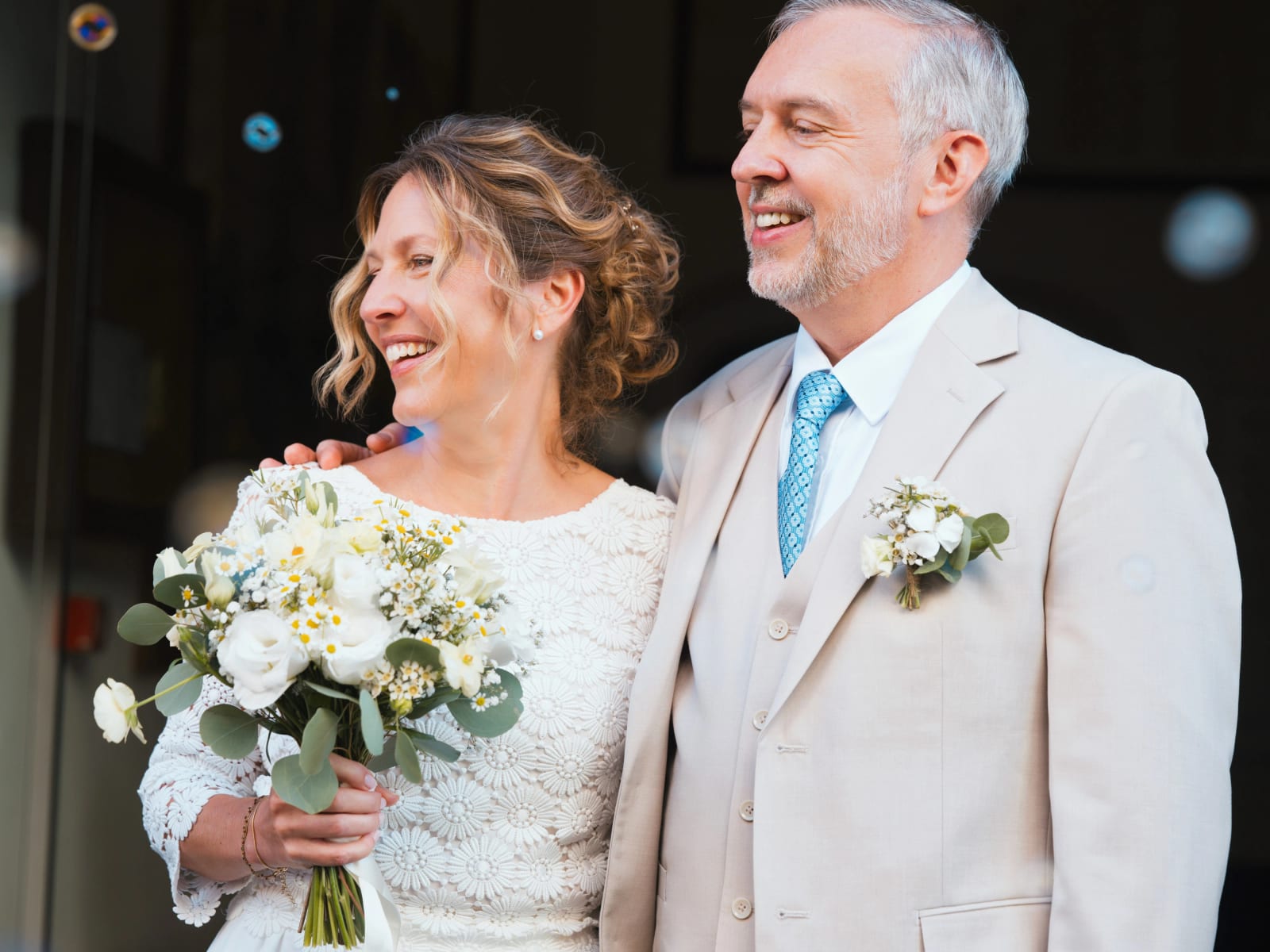 Les mariés riant en sortie de mairie, bouquet blanc et vert à l'eucalyptus au premier plan, mariage à la Mairie de Senlis, par Jean-Baptiste Argyre (Jaysphotography)
