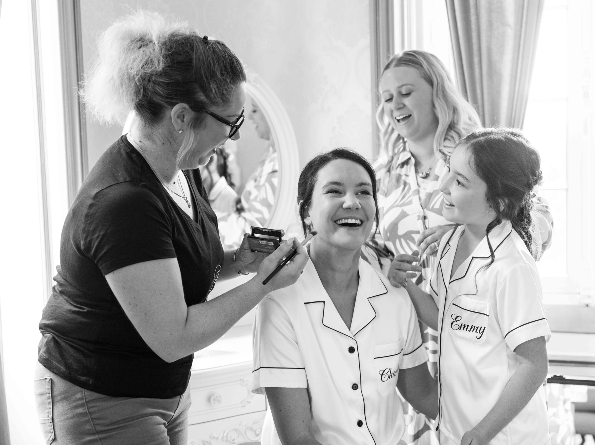 Charline au maquillage entourée de ses demoiselles en pyjamas brodés, noir et blanc, mariage au Château de Moliens, par Jean-Baptiste Argyre (Jaysphotography)