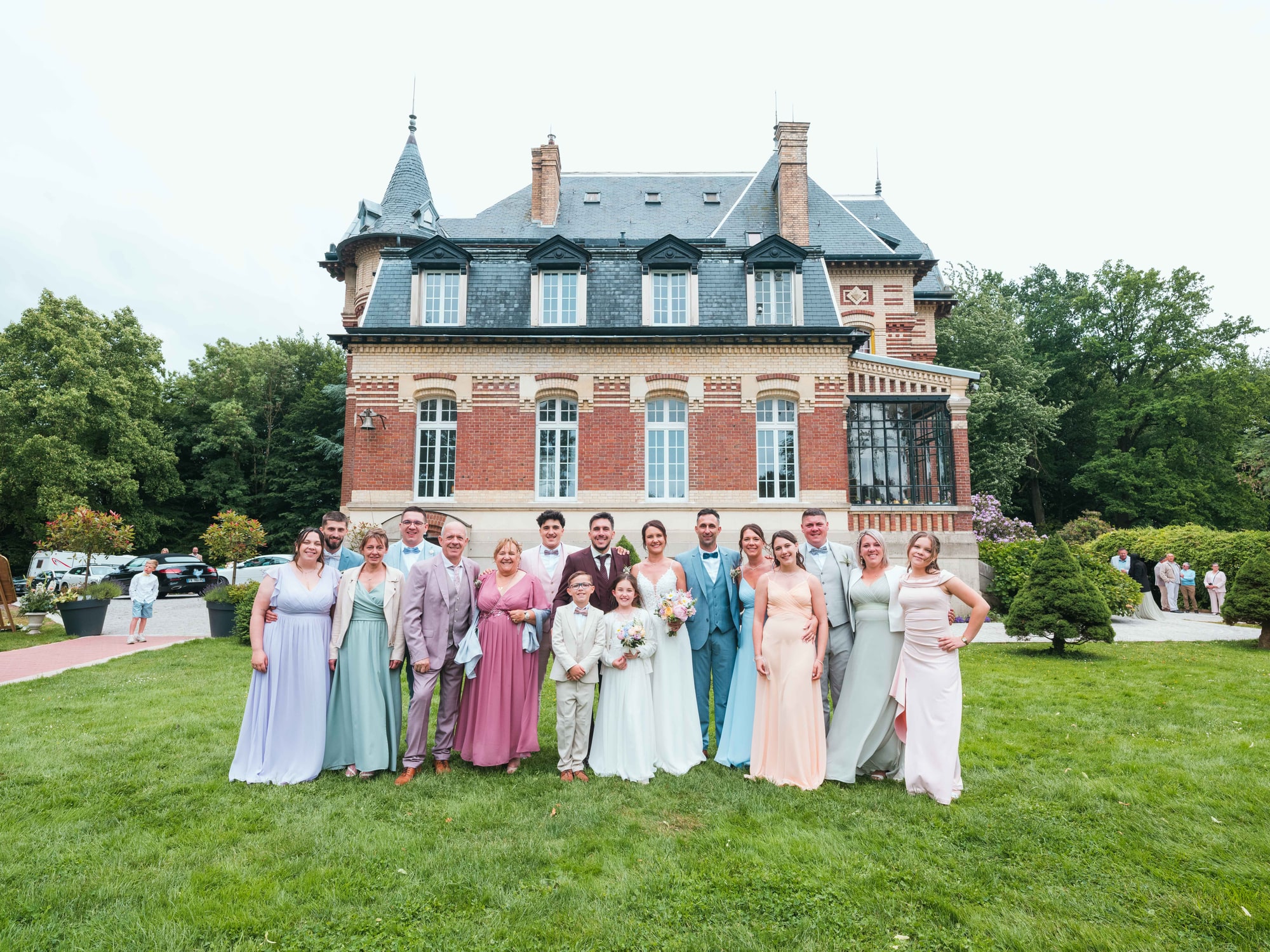 Photo de groupe devant la façade de brique du Château de Moliens, mariage au Château de Moliens, par Jean-Baptiste Argyre (Jaysphotography)