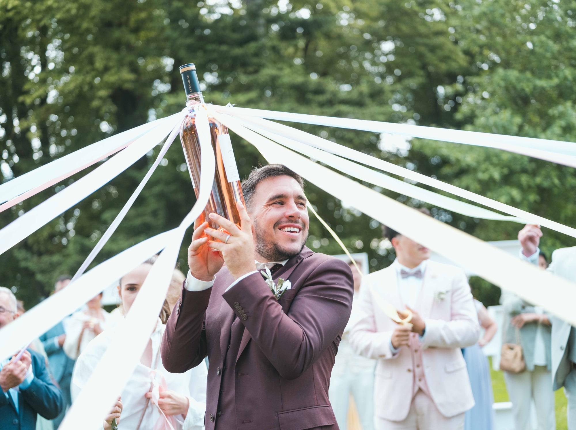 Jonathan au centre du jeu des rubans dans le parc du château, mariage au Château de Moliens, par Jean-Baptiste Argyre (Jaysphotography)
