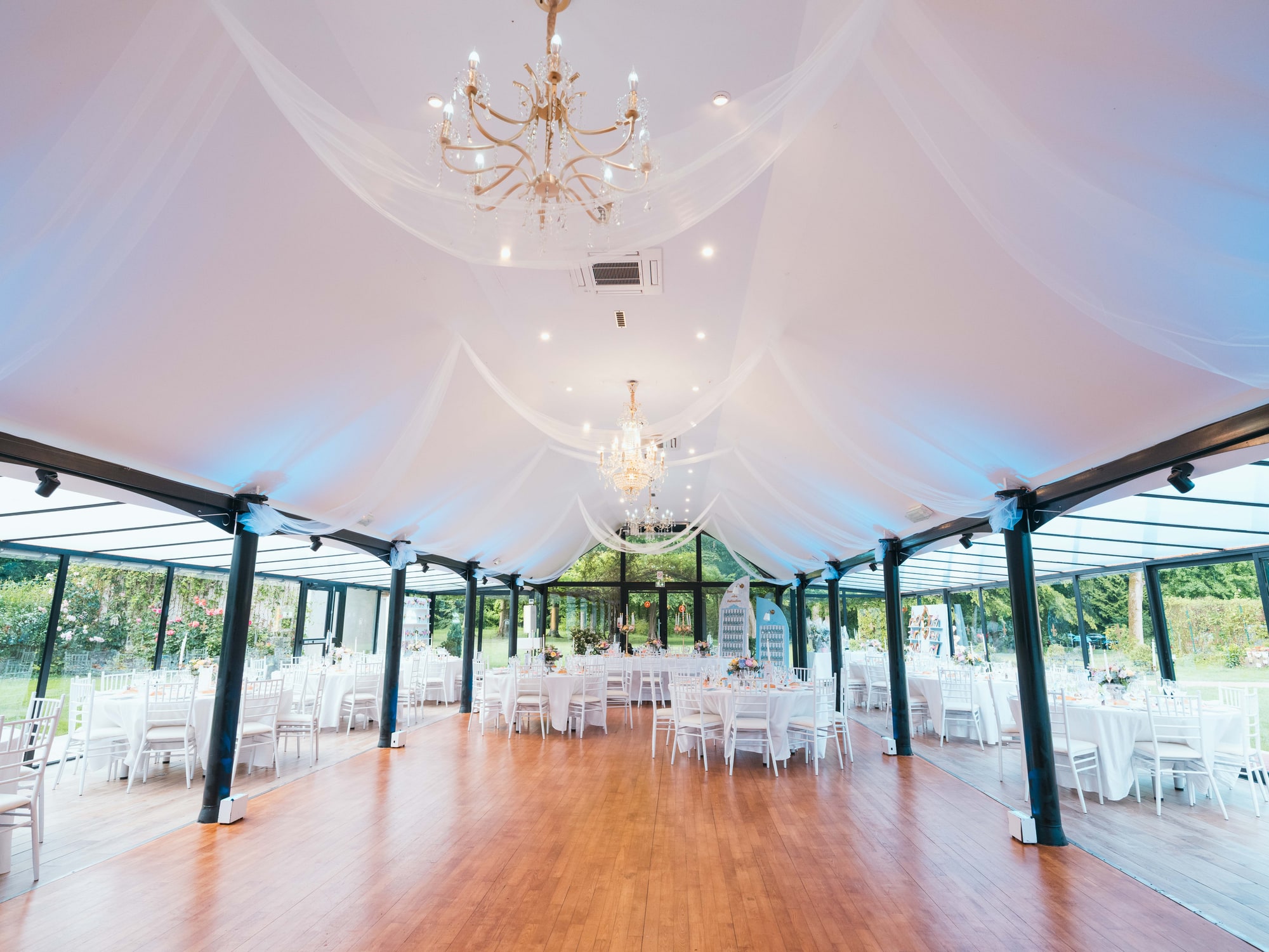 La verrière de réception du Château de Moliens, voilages et lustre, mariage au Château de Moliens, par Jean-Baptiste Argyre (Jaysphotography)