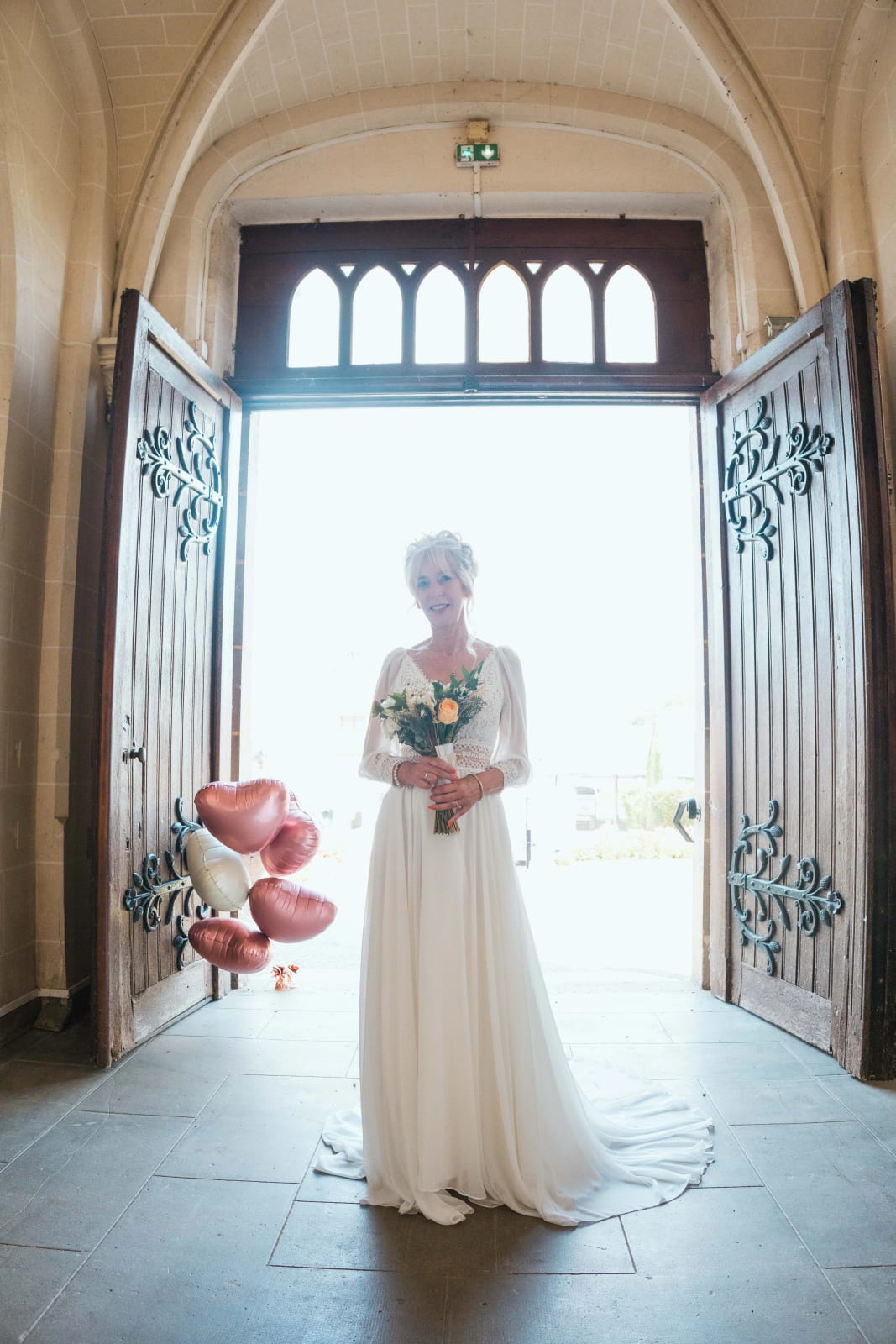 Corinne dans la lumière du porche de l'église de Saint-Remy-en-l'Eau, mariage au Valescourt (Oise), par Jean-Baptiste Argyre (Jaysphotography)