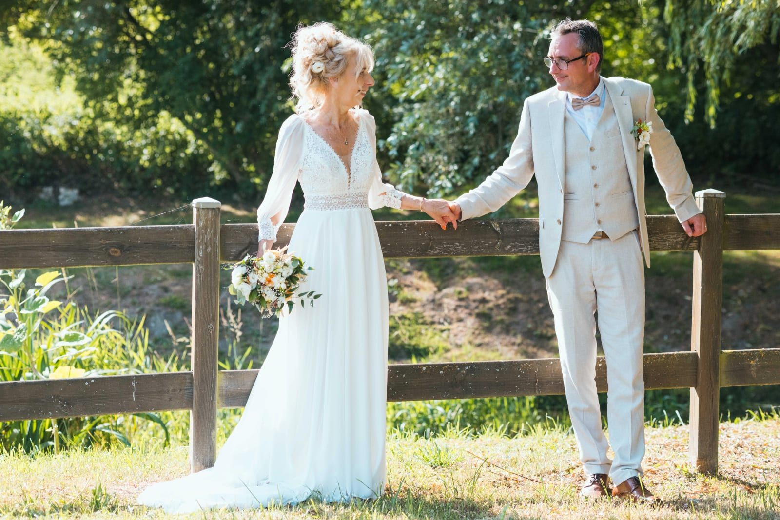 Corinne et Olivier main dans la main le long d'une barrière de bois, mariage au Valescourt (Oise), par Jean-Baptiste Argyre (Jaysphotography)