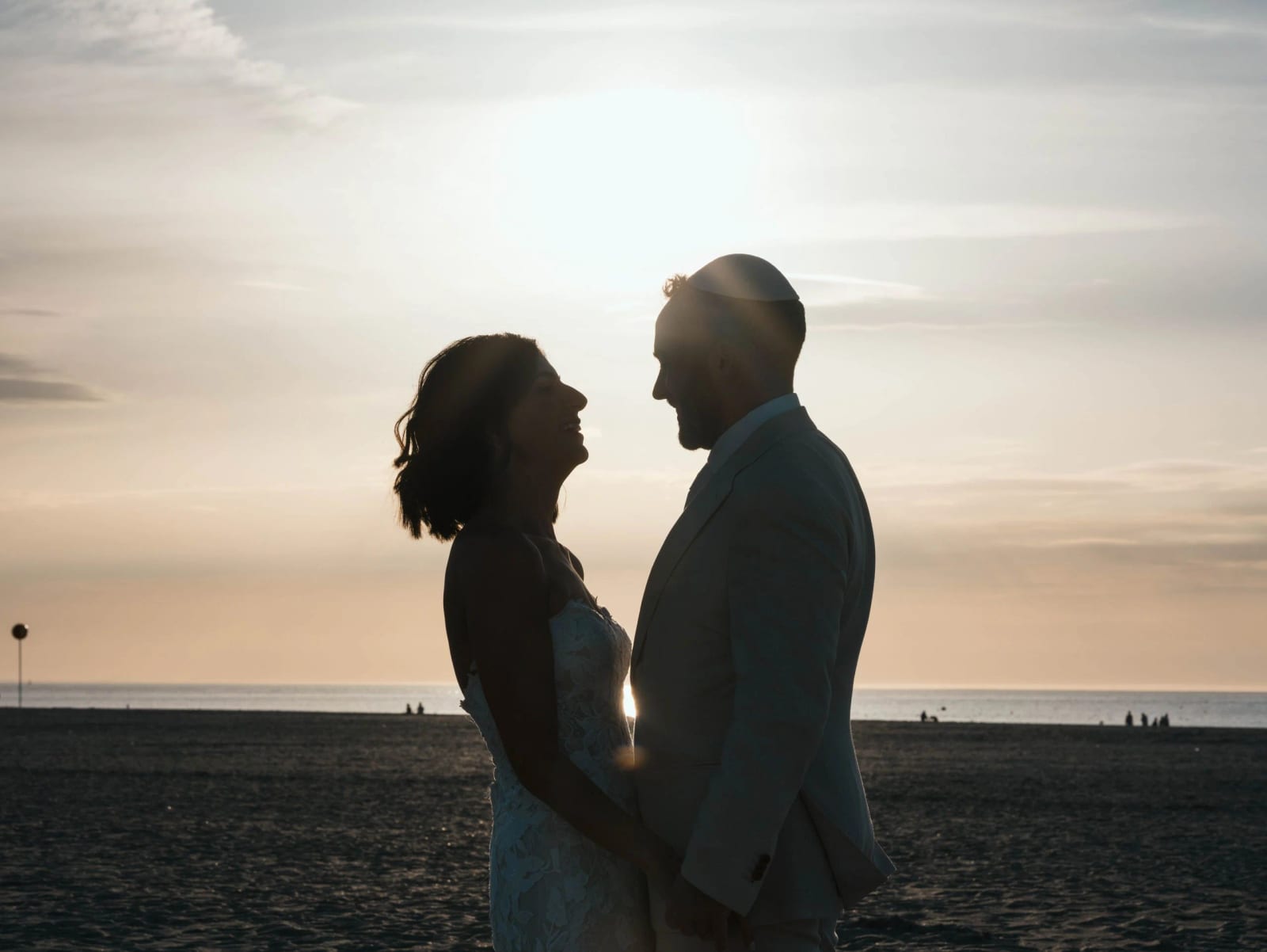 Silhouettes des mariés face à face au coucher du soleil sur la plage de Deauville, mariage au Pavillon des Bains, Deauville, par Jean-Baptiste Argyre (Jaysphotography)