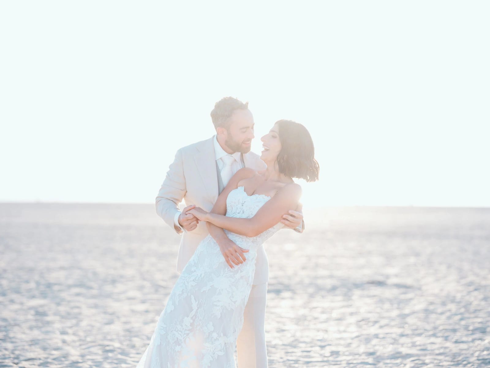 Les mariés rient enlacés sur la plage de Deauville dans la lumière de fin de journée, mariage au Pavillon des Bains, Deauville, par Jean-Baptiste Argyre (Jaysphotography)