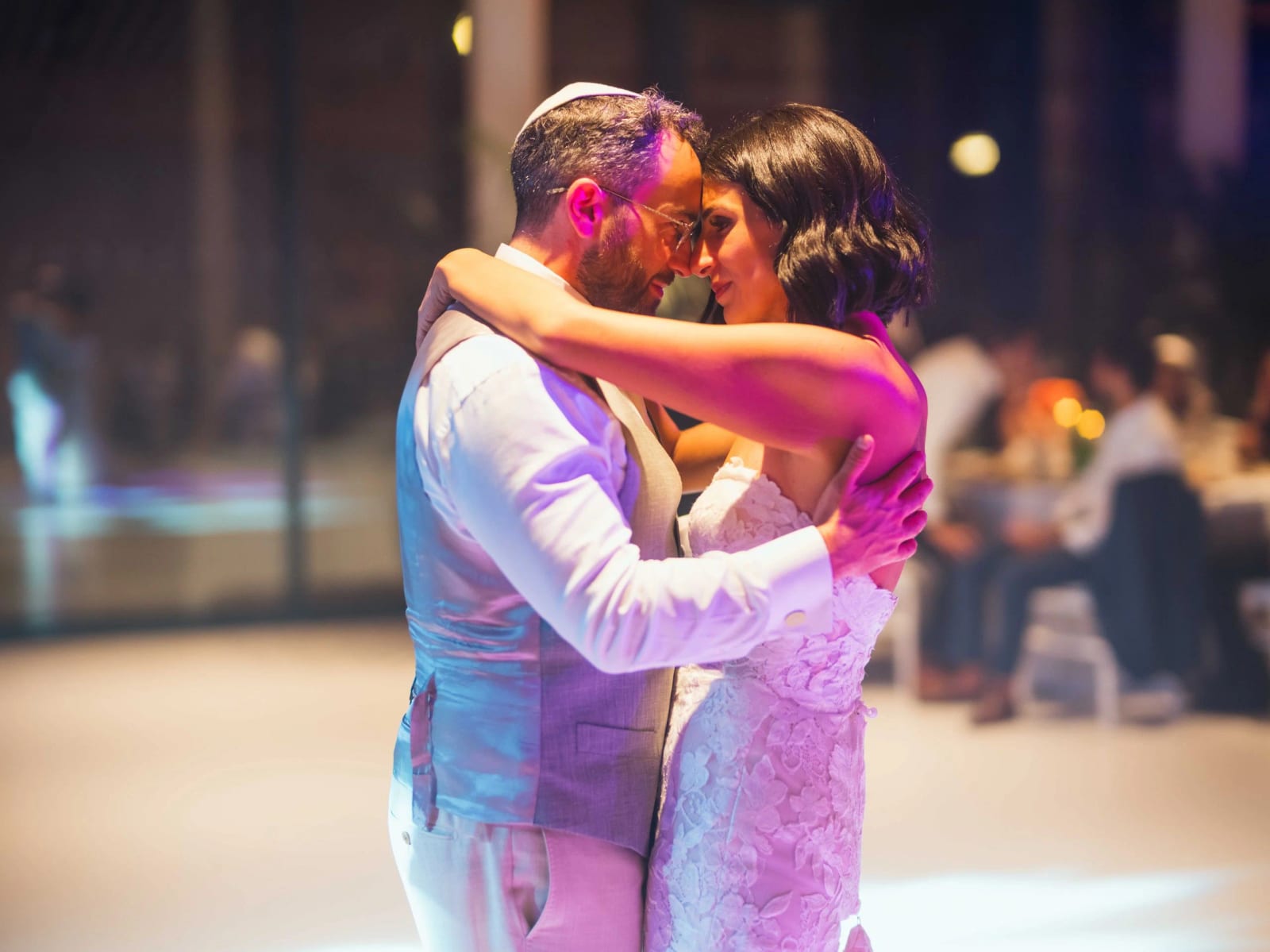 Première danse front contre front sous la lumière violette, invités attablés derrière, mariage au Pavillon des Bains, Deauville, par Jean-Baptiste Argyre (Jaysphotography)