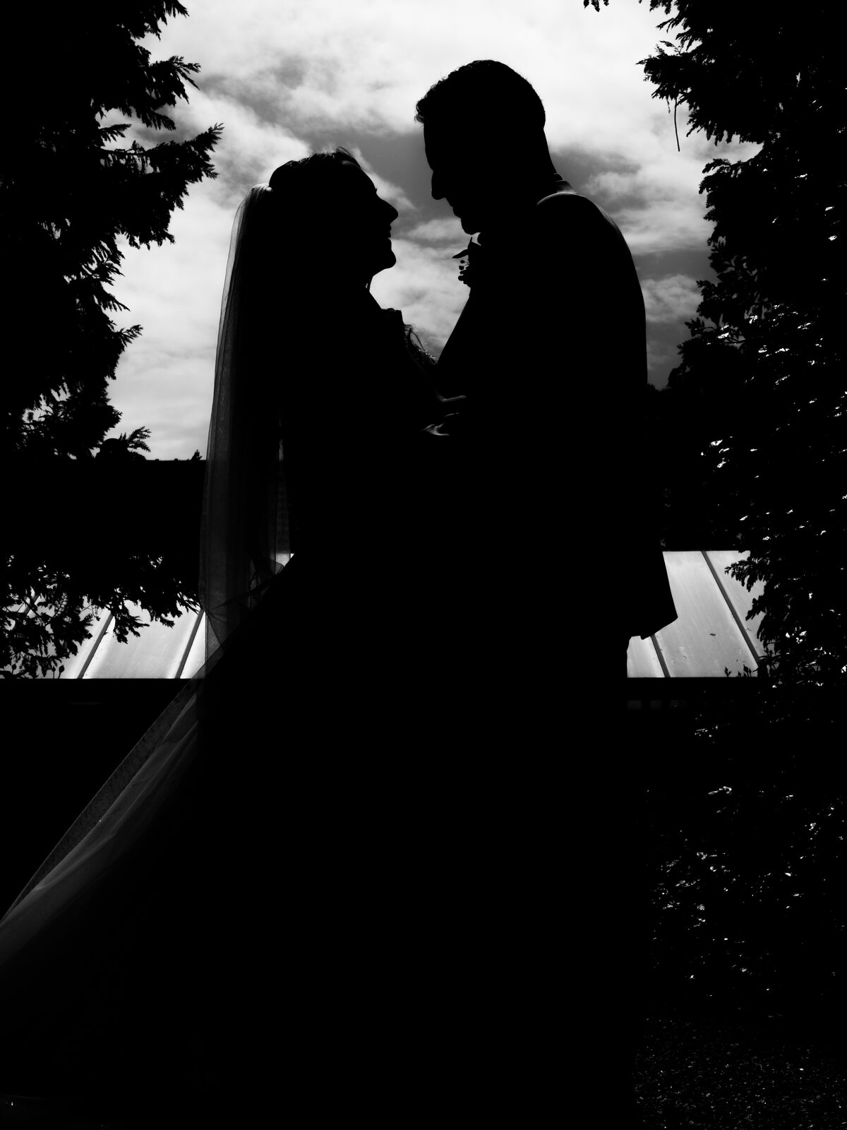 Silhouette des mariés face à face en contre-jour noir et blanc devant le ciel — mariage au Château de Naours, par Jean-Baptiste Argyre (Jaysphotography)