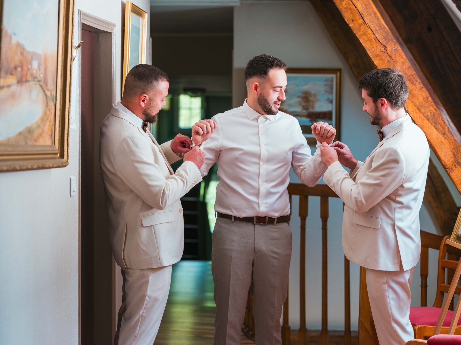 Grégory et ses deux témoins ajustent leurs boutons de manchette dans les combles du château — mariage au Château de Naours, par Jean-Baptiste Argyre (Jaysphotography)