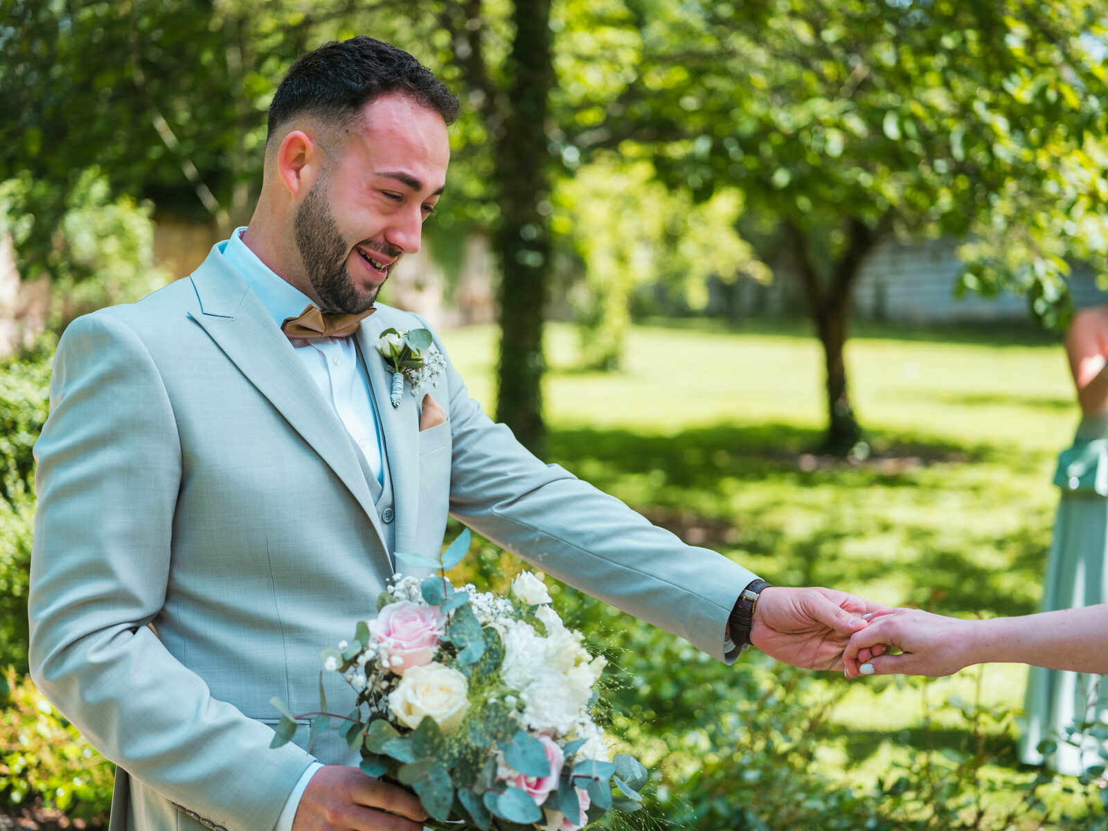 First look ému : Grégory découvre Émilie, bouquet en main, dans le parc ensoleillé — mariage au Château de Naours, par Jean-Baptiste Argyre (Jaysphotography)