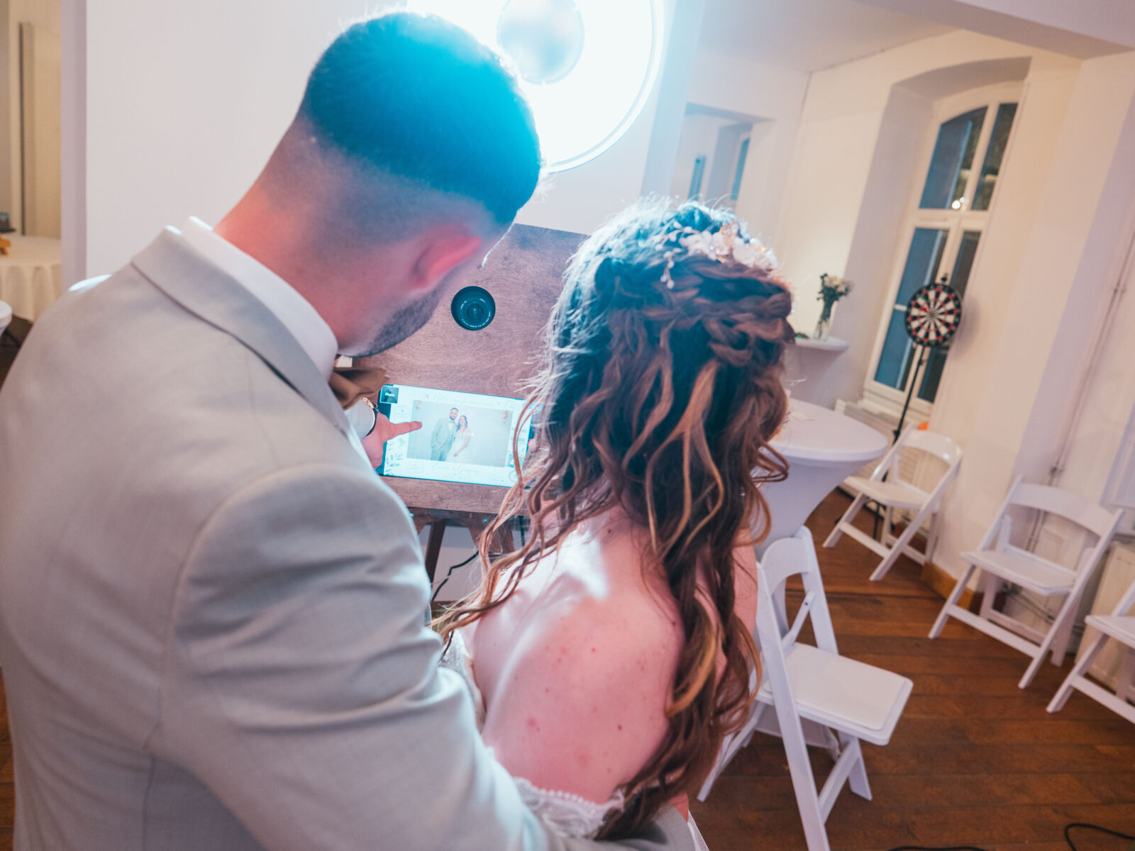 Grégory et Émilie découvrent leur cliché sur la borne photo pendant la soirée — mariage au Château de Naours, par Jean-Baptiste Argyre (Jaysphotography)
