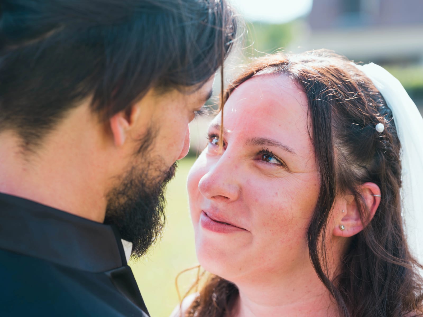 Regard complice de Jessie vers Aurélien, voile et perles dans les cheveux, mariage au Domaine de l'Orangerie de Villette, par Jean-Baptiste Argyre (Jaysphotography)