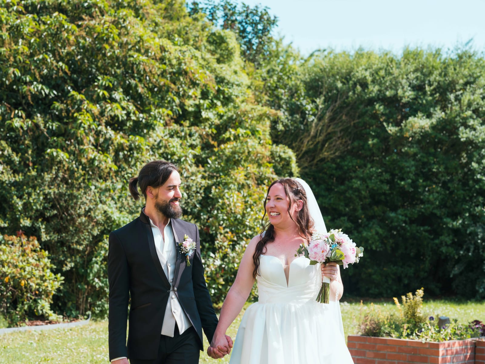 Jessie et Aurélien marchant main dans la main dans la verdure, mariage au Domaine de l'Orangerie de Villette, par Jean-Baptiste Argyre (Jaysphotography)
