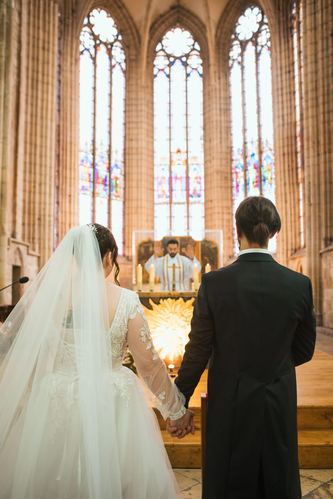 Jessie et Aurélien de dos sous les voûtes gothiques de l'église de Chambly, mariage au Domaine de l'Orangerie de Villette, par Jean-Baptiste Argyre (Jaysphotography)