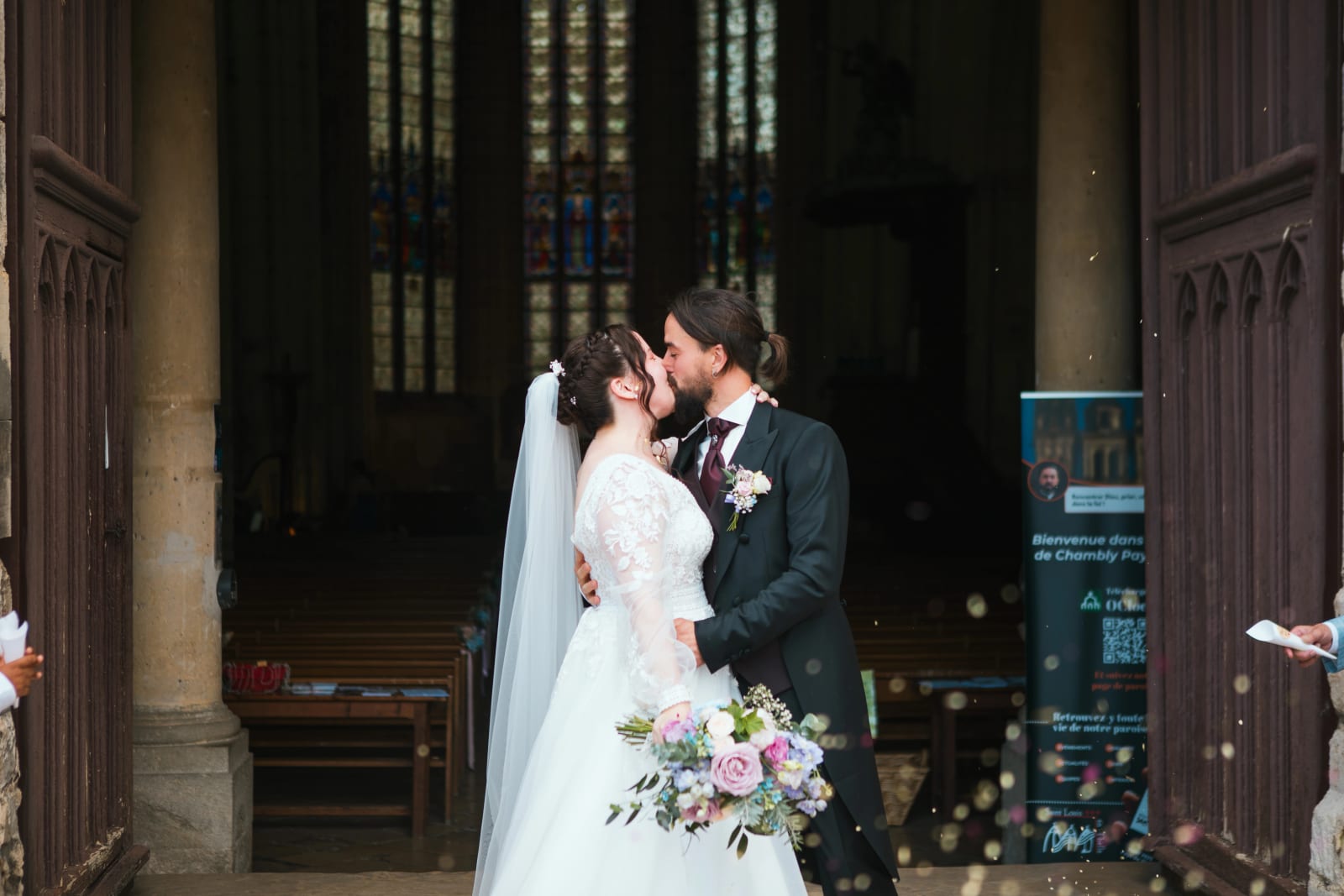 Baiser de Jessie et Aurélien dans l'église de Chambly, bouquet pastel, mariage au Domaine de l'Orangerie de Villette, par Jean-Baptiste Argyre (Jaysphotography)