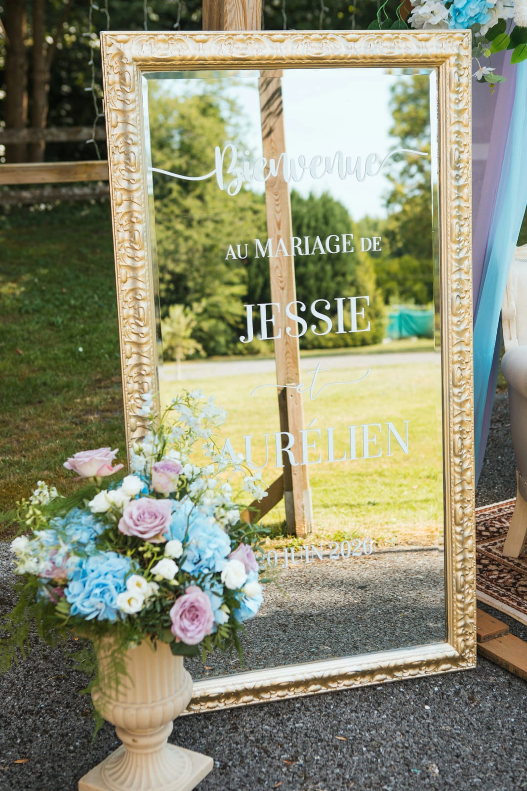 Miroir doré de bienvenue aux prénoms de Jessie et Aurélien, fleurs pastel, mariage au Domaine de l'Orangerie de Villette, par Jean-Baptiste Argyre (Jaysphotography)