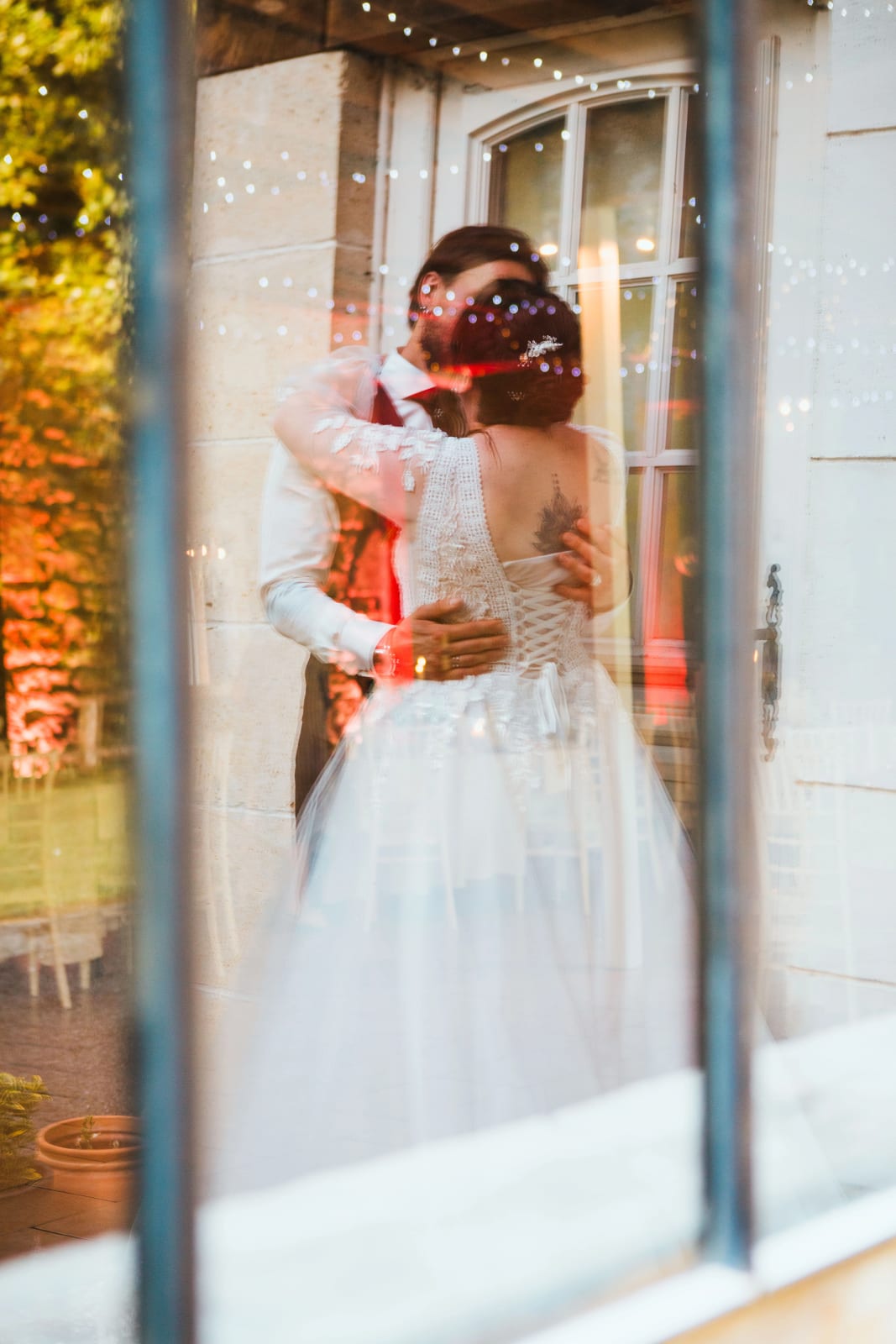 Reflet du baiser des mariés dans la fenêtre du domaine, mariage au Domaine de l'Orangerie de Villette, par Jean-Baptiste Argyre (Jaysphotography)