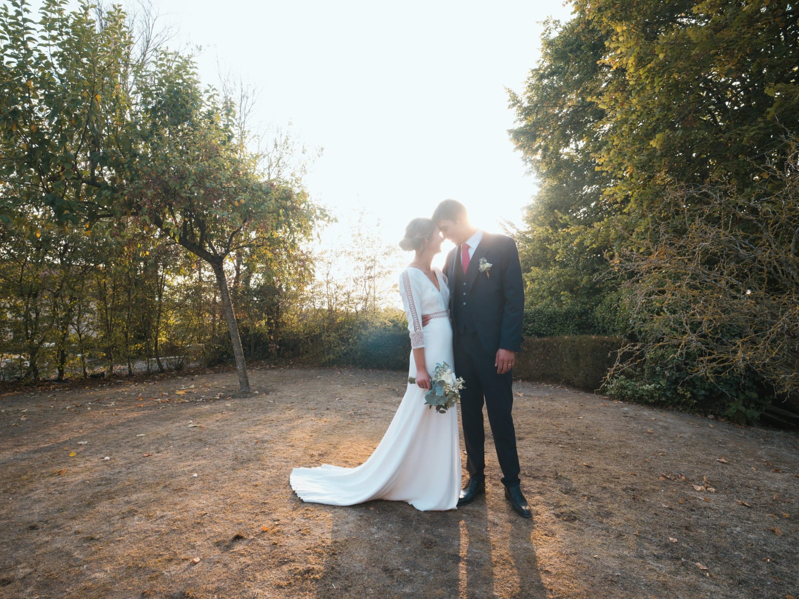 Les mariés front contre front dans la lumière rasante du soir, haies et arbres autour, mariage au Domaine le Pommerieux, Buzancy, par Jean-Baptiste Argyre (Jaysphotography)