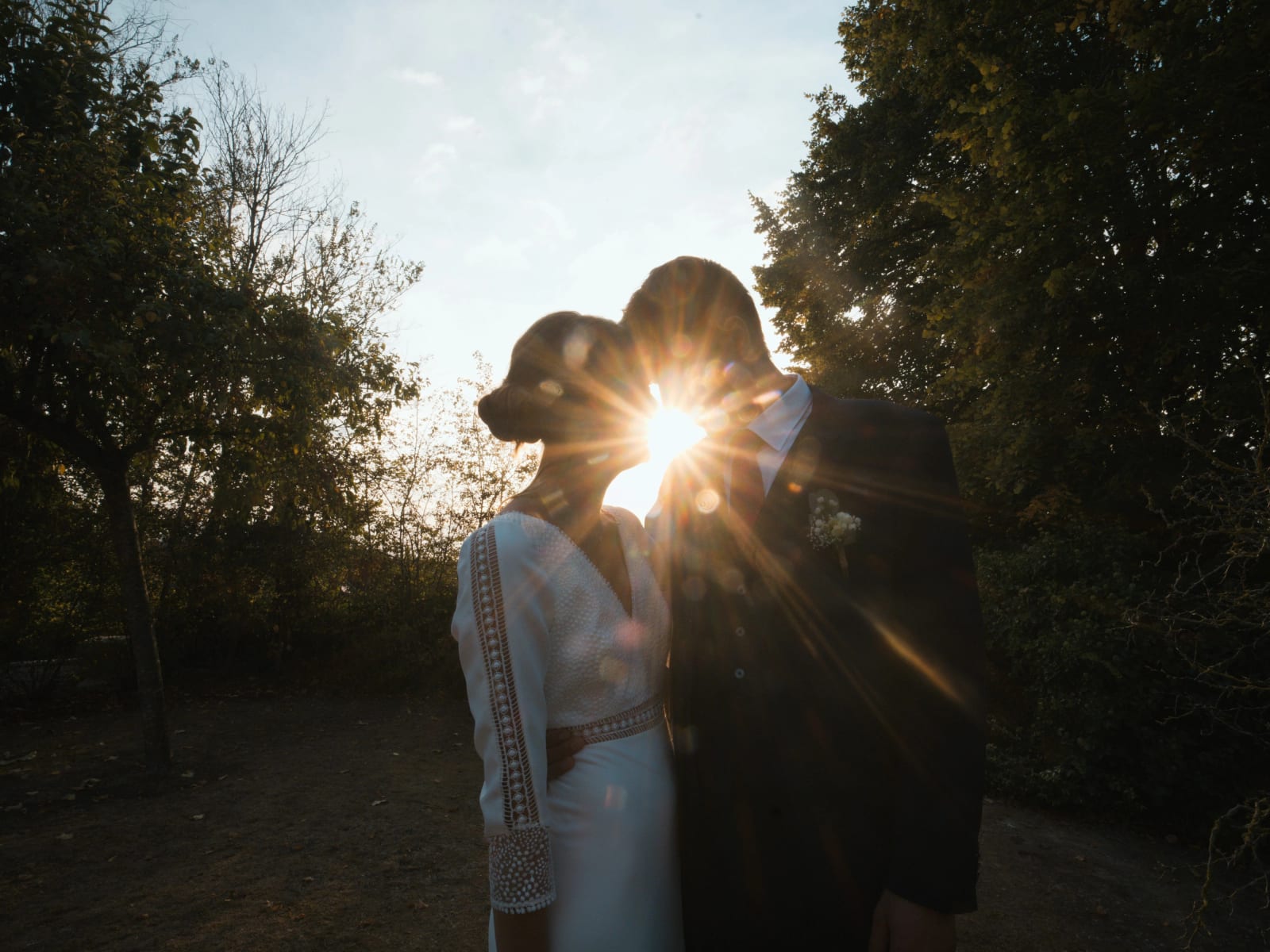 Silhouette des mariés à contre-jour, l'étoile du soleil entre leurs visages, mariage au Domaine le Pommerieux, Buzancy, par Jean-Baptiste Argyre (Jaysphotography)