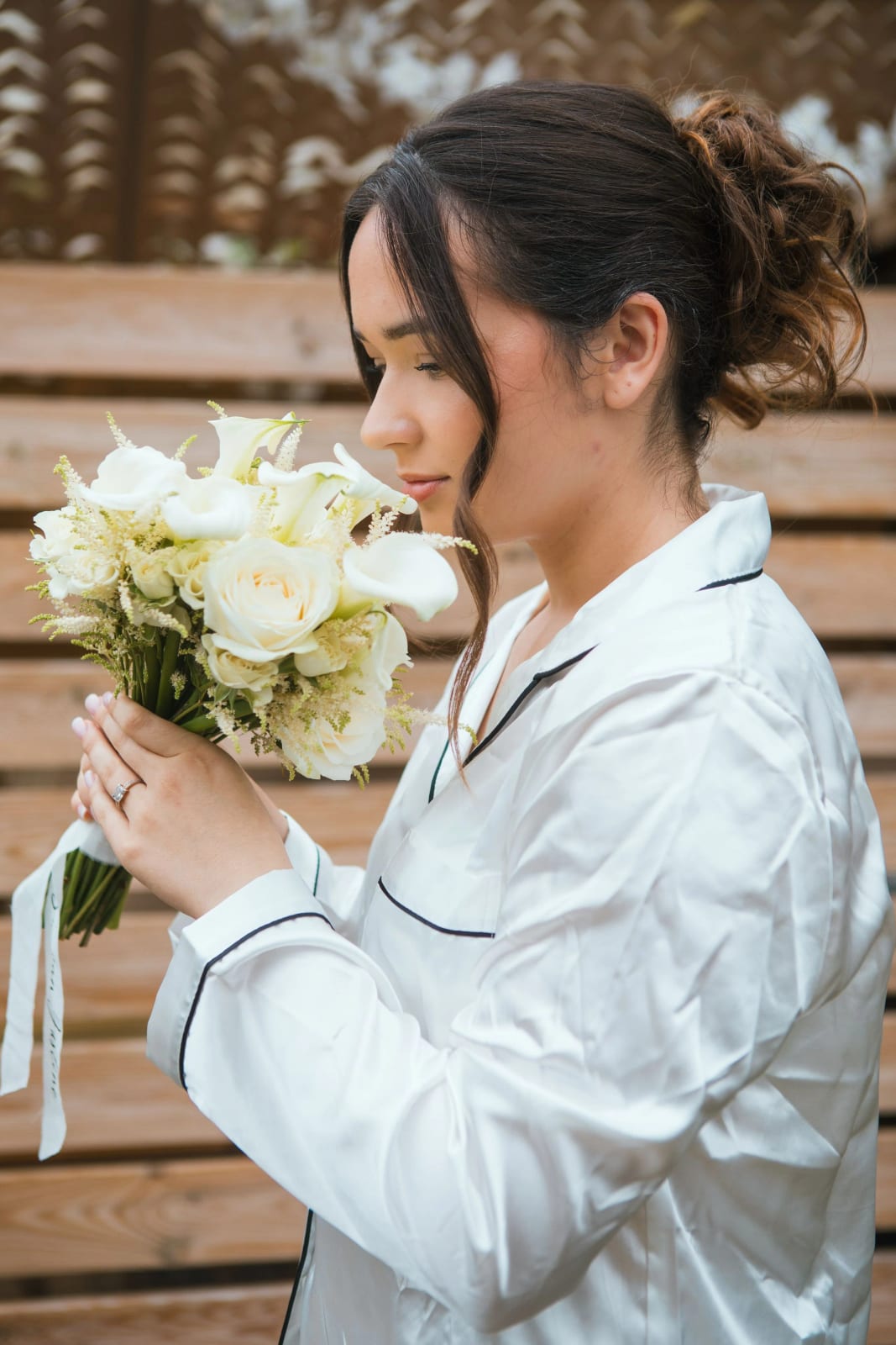 La mariée en pyjama de satin découvre son bouquet de roses blanches et d'arums, Nogent-sur-Oise, mariage à la Salle Georges Brassens, Villers-Saint-Paul, par Jean-Baptiste Argyre (Jaysphotography)