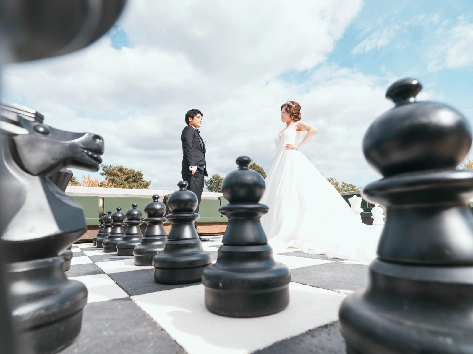 Les mariés vus au ras du sol entre les pièces noires d'un échiquier géant, cavalier au premier plan, mariage au Château Mont Royal, par Jean-Baptiste Argyre (Jaysphotography)