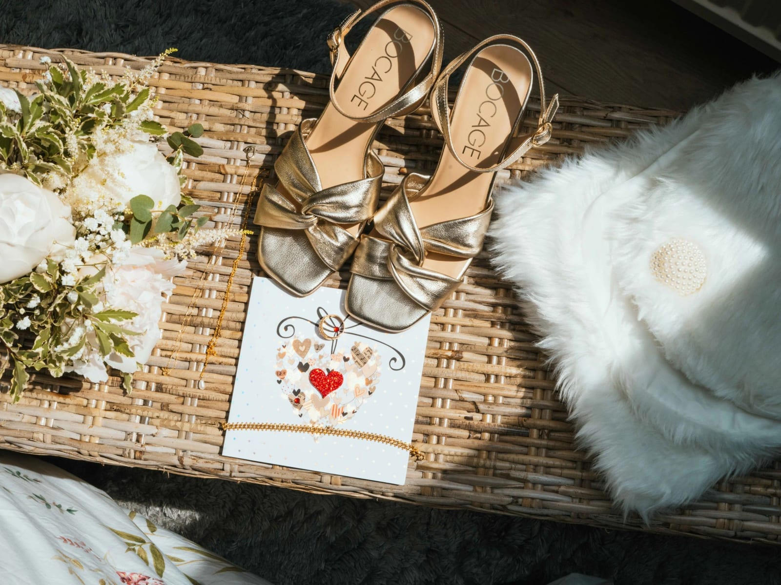 Les escarpins dorés, le bouquet blanc et la carte de vœux de Lydia posés en flat lay, mariage au Domaine la Ferme du Roy, par Jean-Baptiste Argyre (Jaysphotography)