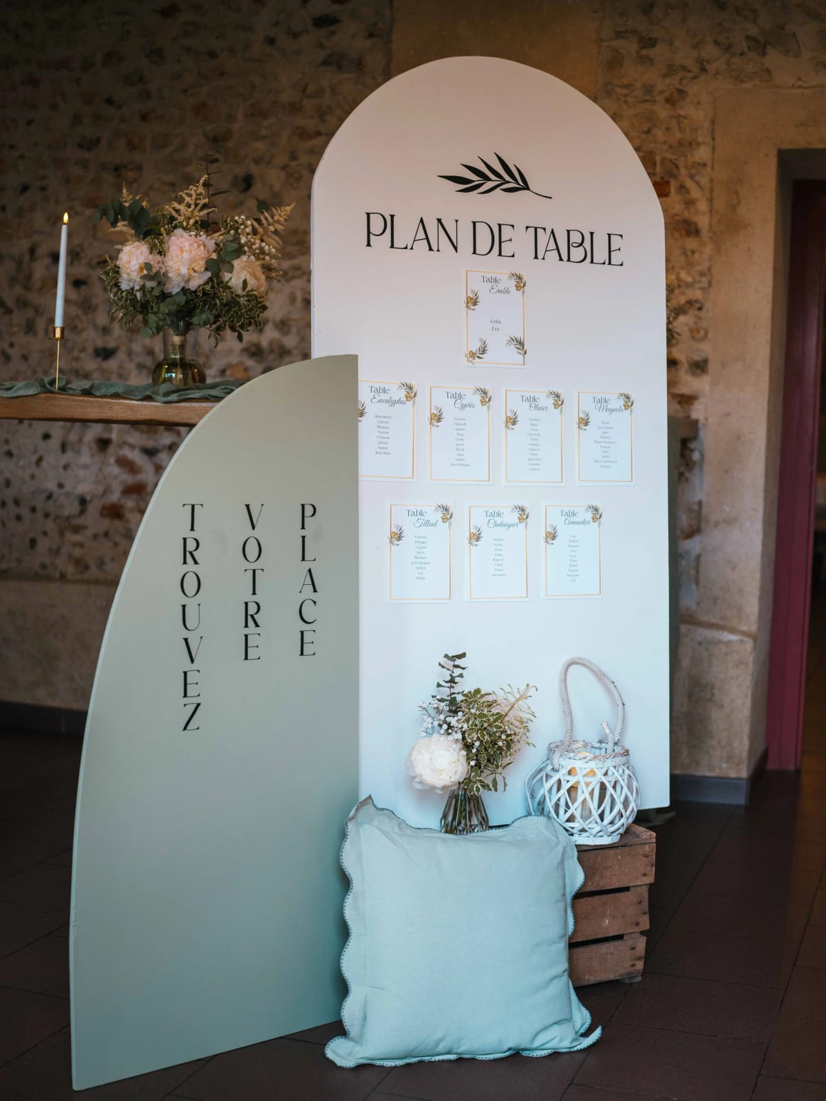 Le plan de table en arche vert sauge Trouvez votre place, dans la salle en pierre du domaine, mariage au Domaine la Ferme du Roy, par Jean-Baptiste Argyre (Jaysphotography)