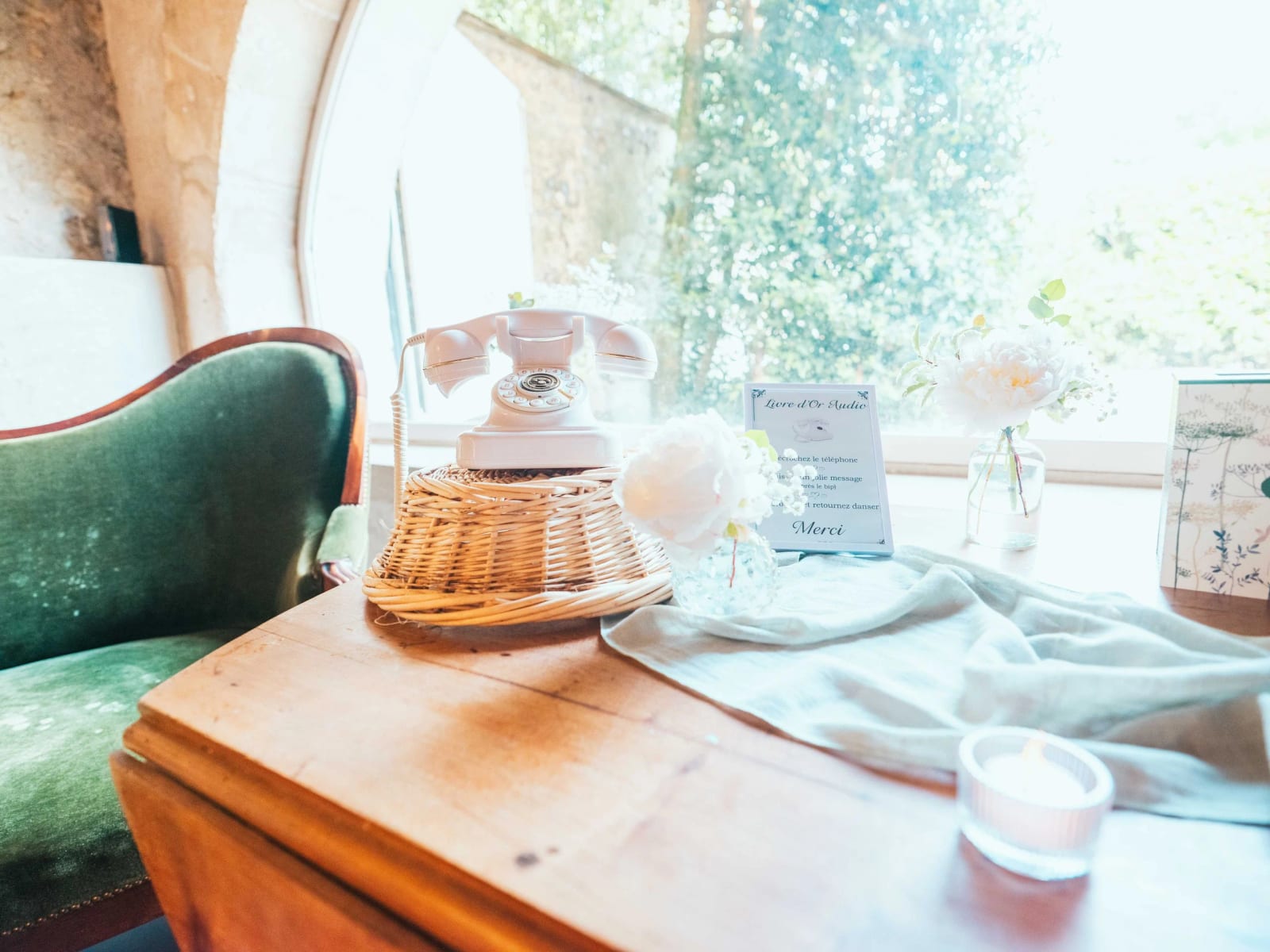 Le livre d'or audio : un téléphone vintage blanc dans un panier en osier pour les messages des invités, mariage au Domaine la Ferme du Roy, par Jean-Baptiste Argyre (Jaysphotography)