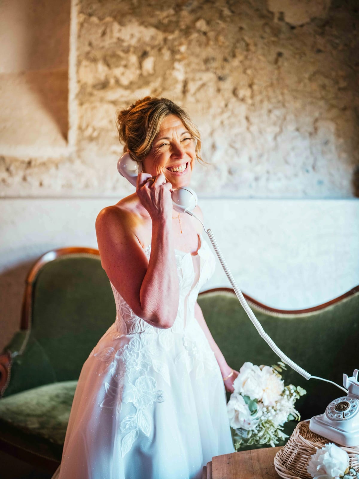 Lydia, espiègle, décroche le combiné du téléphone vintage du livre d'or audio, mariage au Domaine la Ferme du Roy, par Jean-Baptiste Argyre (Jaysphotography)