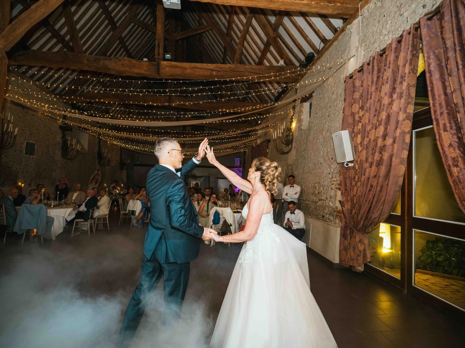 Ouverture de bal de Lydia et Éric sous les guirlandes, nappe de fumée au sol, mariage au Domaine la Ferme du Roy, par Jean-Baptiste Argyre (Jaysphotography)