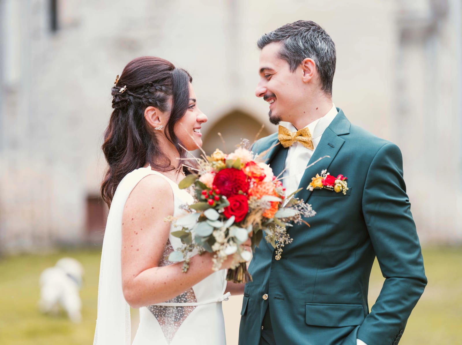 Les mariés se sourient devant le mur en ruine, le chien au loin dans l'herbe, mariage à l'Abbaye de Longpont, par Jean-Baptiste Argyre (Jaysphotography)