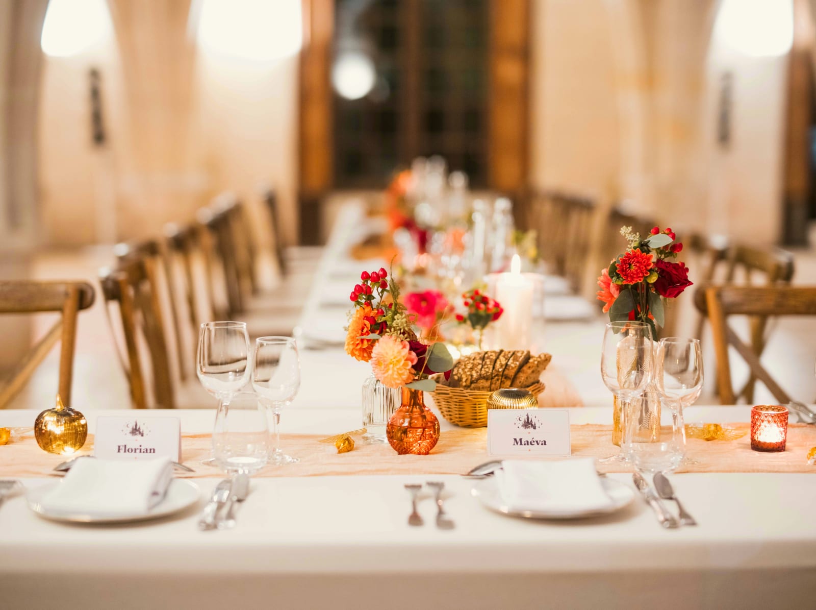Table du dîner : marque-places de Florian et Maéva, vases ambrés de dahlias, chemin de table pêche, pommes dorées et photophores, mariage à l'Abbaye de Longpont, par Jean-Baptiste Argyre (Jaysphotography)