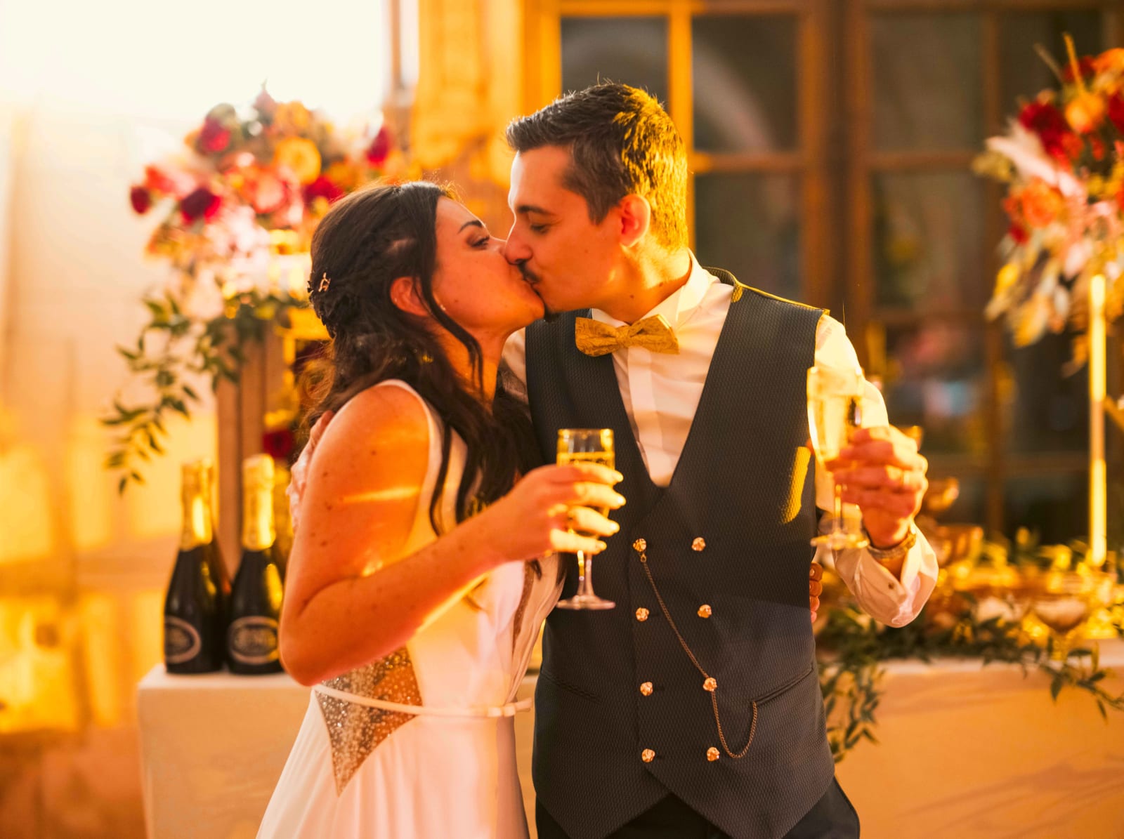 Les mariés s'embrassent coupe de champagne à la main, le marié en gilet avec chaîne de montre, mariage à l'Abbaye de Longpont, par Jean-Baptiste Argyre (Jaysphotography)