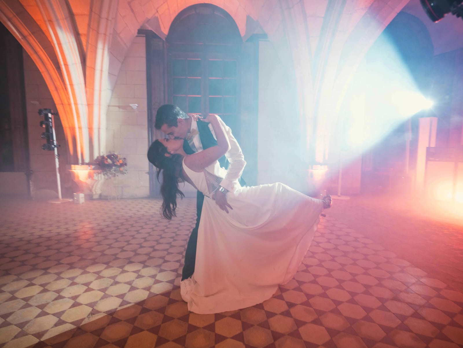 Les mariés terminent leur première danse en renversé sous un faisceau de projecteur bleu, mariage à l'Abbaye de Longpont, par Jean-Baptiste Argyre (Jaysphotography)