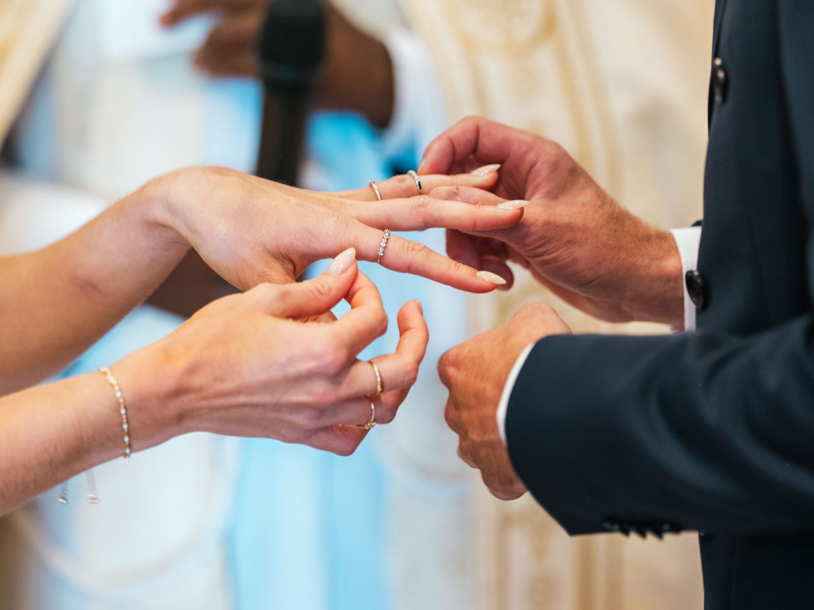 Échange des alliances en gros plan pendant la cérémonie religieuse du mariage de Mathilde et Paul, mariage au Château de Moliens, par Jean-Baptiste Argyre (Jaysphotography)