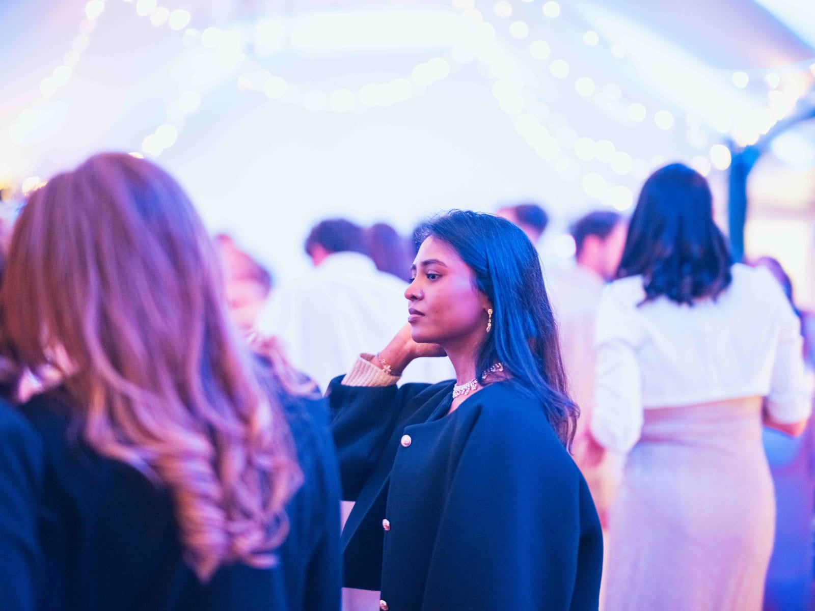 Portrait d'une invitée dans les lumières bleues et violettes de la soirée sous les guirlandes, mariage au Château de Moliens, par Jean-Baptiste Argyre (Jaysphotography)