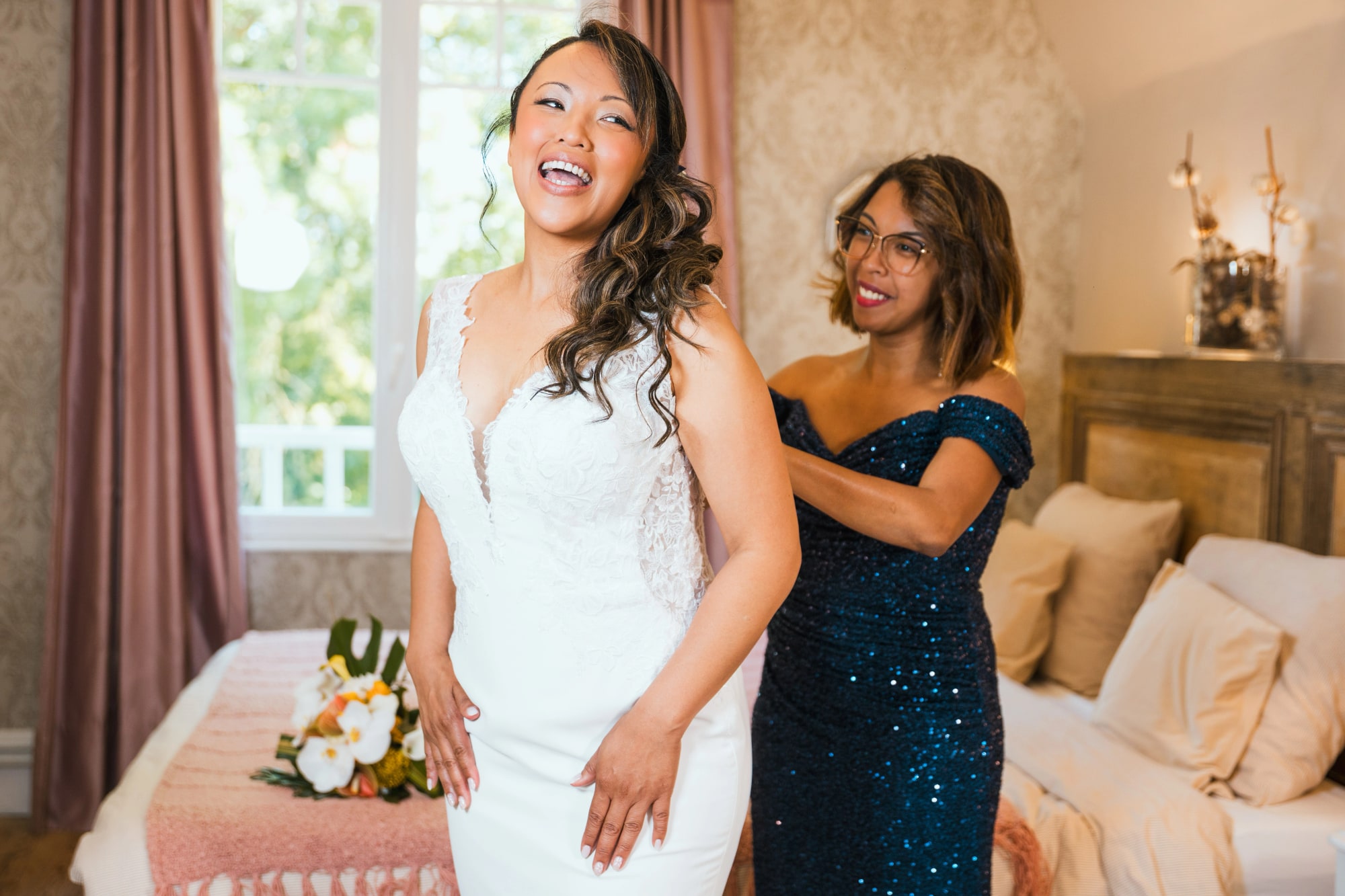 Nanou en robe de mariée riant avec son témoin en bleu pailleté, mariage au La Ferme de la Biza, par Jean-Baptiste Argyre (Jaysphotography)