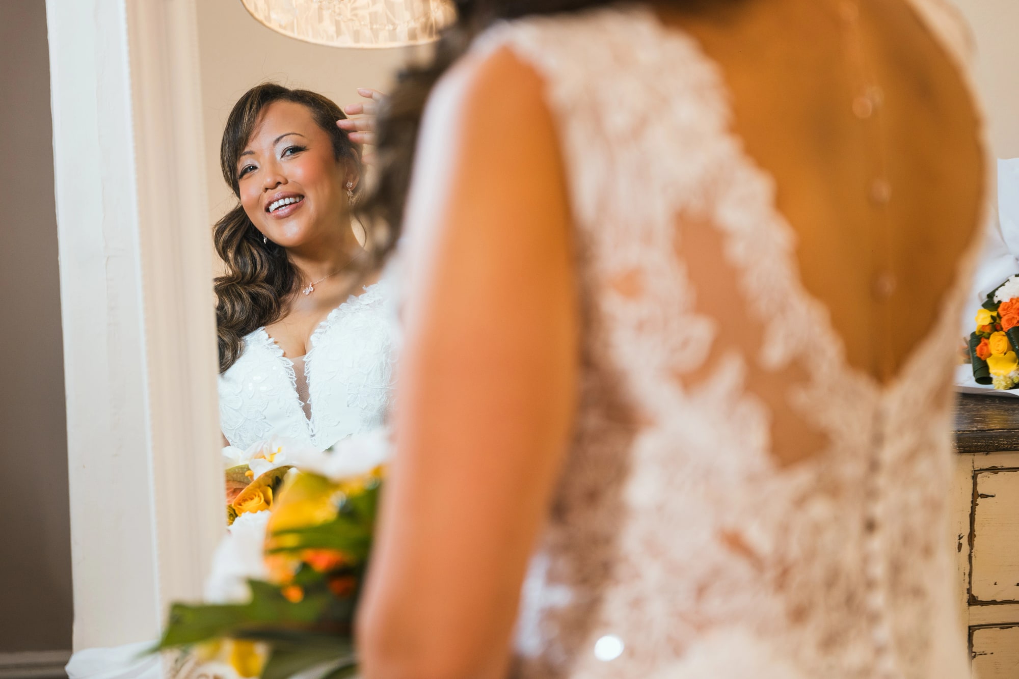 Portrait de Nanou par-dessus l'épaule, dos en dentelle de la robe, mariage au La Ferme de la Biza, par Jean-Baptiste Argyre (Jaysphotography)