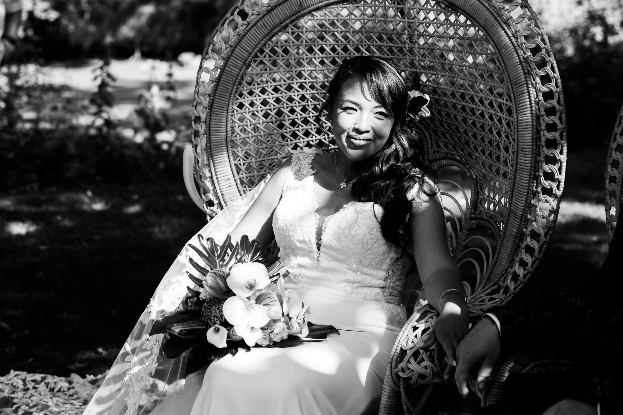 Nanou en noir et blanc dans le fauteuil en rotin de la cérémonie, mariage au La Ferme de la Biza, par Jean-Baptiste Argyre (Jaysphotography)