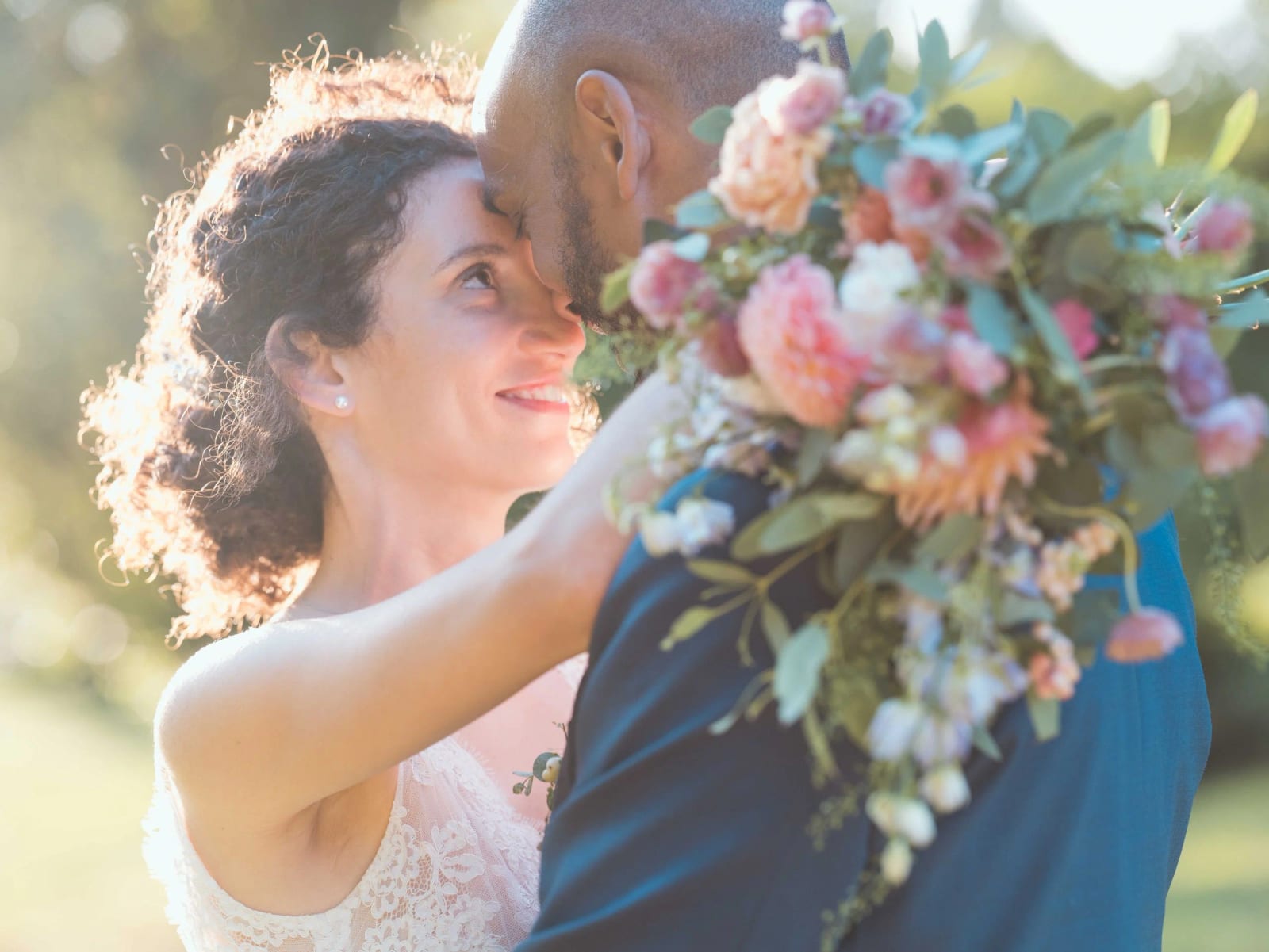 Portrait serré des mariés front contre front, bouquet de roses et fleurs pastel contre l'épaule du marié, mariage au Château de Reilly, par Jean-Baptiste Argyre (Jaysphotography)