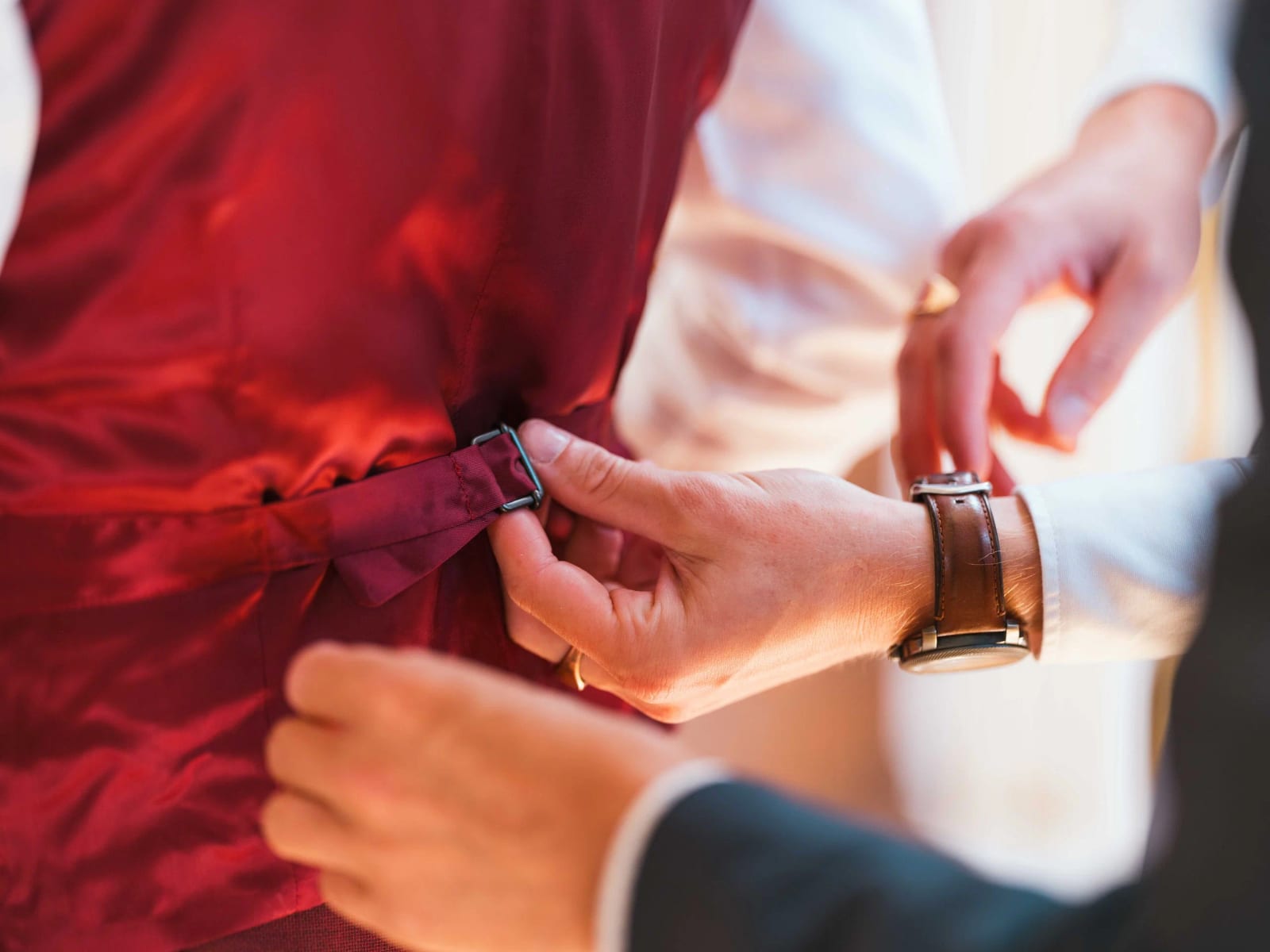 Le marié ajuste sa manche et sa montre au-dessus de la veste bordeaux, préparatifs du mariage de Noémie et Alexandre, mariage au Château de Moliens, par Jean-Baptiste Argyre (Jaysphotography)