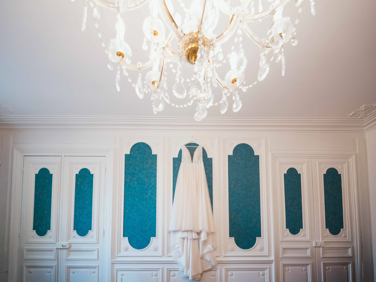 Robe de mariée suspendue au lustre d'un salon du Château des Granges, mariage au Château des Granges, par Jean-Baptiste Argyre (Jaysphotography)