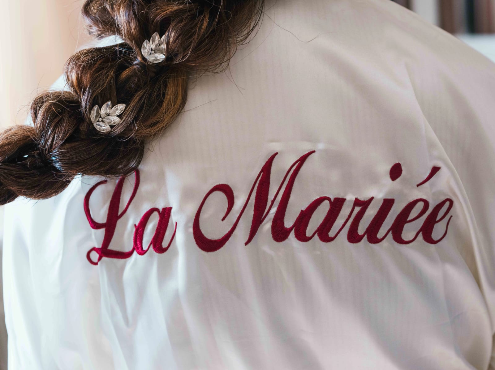 Tresse fleurie de Pauline et peignoir brodé La Mariée, mariage au Château des Granges, par Jean-Baptiste Argyre (Jaysphotography)