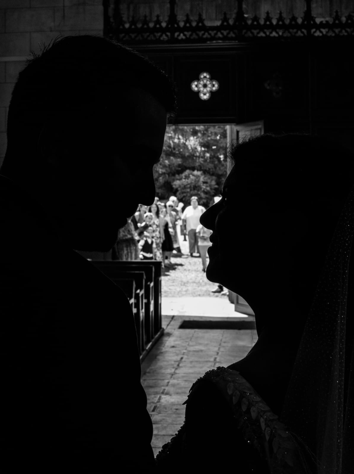 Silhouette des mariés en contre-jour dans le portail de l'église, mariage au Château des Granges, par Jean-Baptiste Argyre (Jaysphotography)