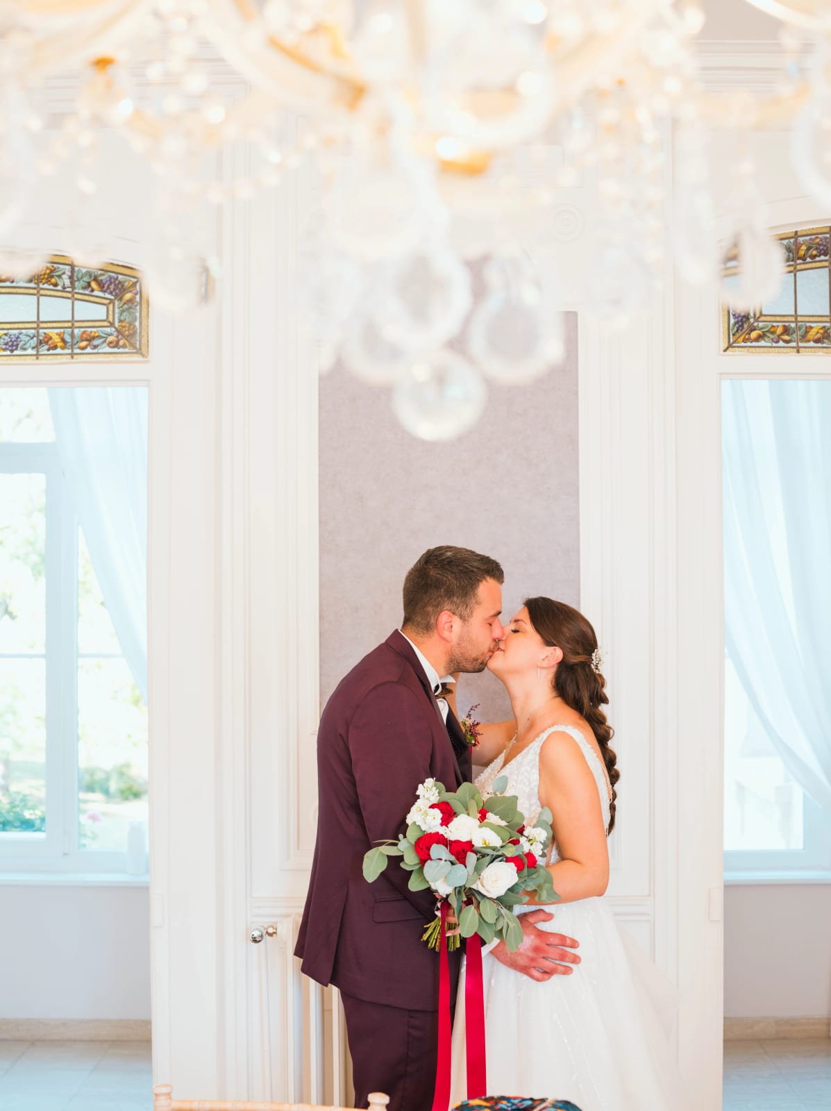 Baiser des mariés dans le salon aux lustres de cristal du château, mariage au Château des Granges, par Jean-Baptiste Argyre (Jaysphotography)