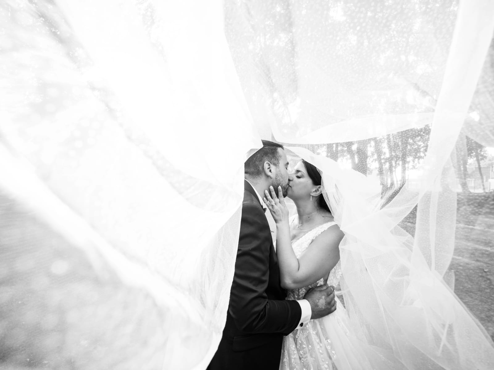 Pauline et Alexandre enlacés sous le voile en noir et blanc, mariage au Château des Granges, par Jean-Baptiste Argyre (Jaysphotography)