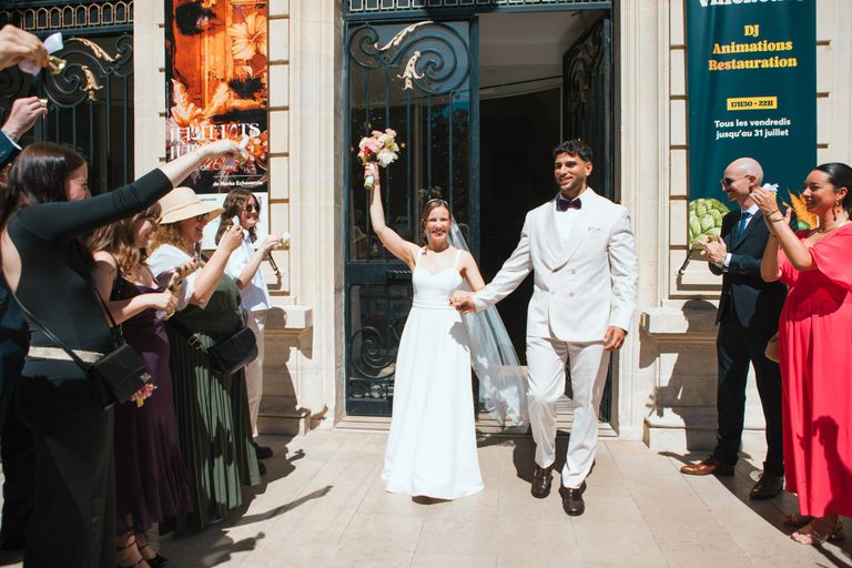 Sortie de la mairie de Clichy sous les applaudissements : Pauline lève son bouquet, Anis lui tient la main
